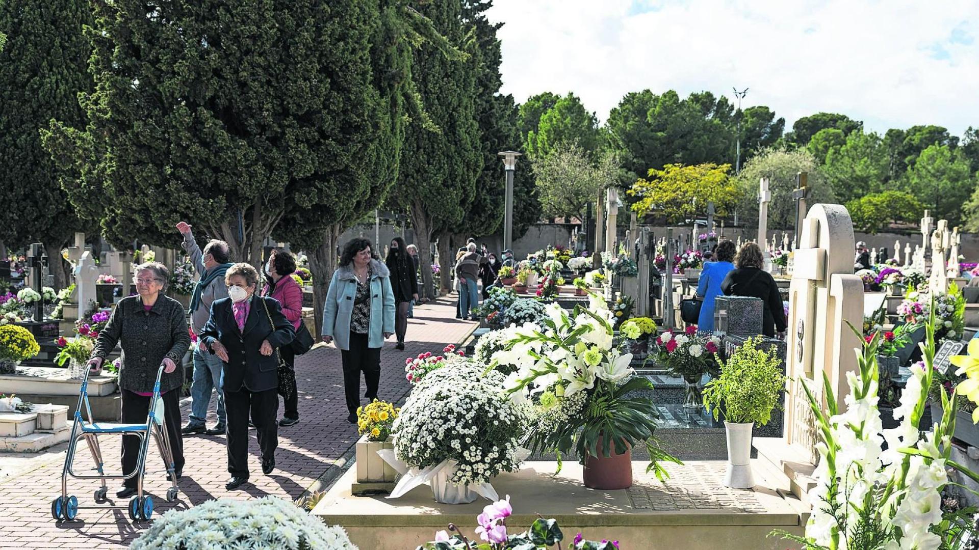 Imagen de una de las zonas de sepulturas en tierra del cementerio municipal de Tudela, con las tumbas adornadas con flores