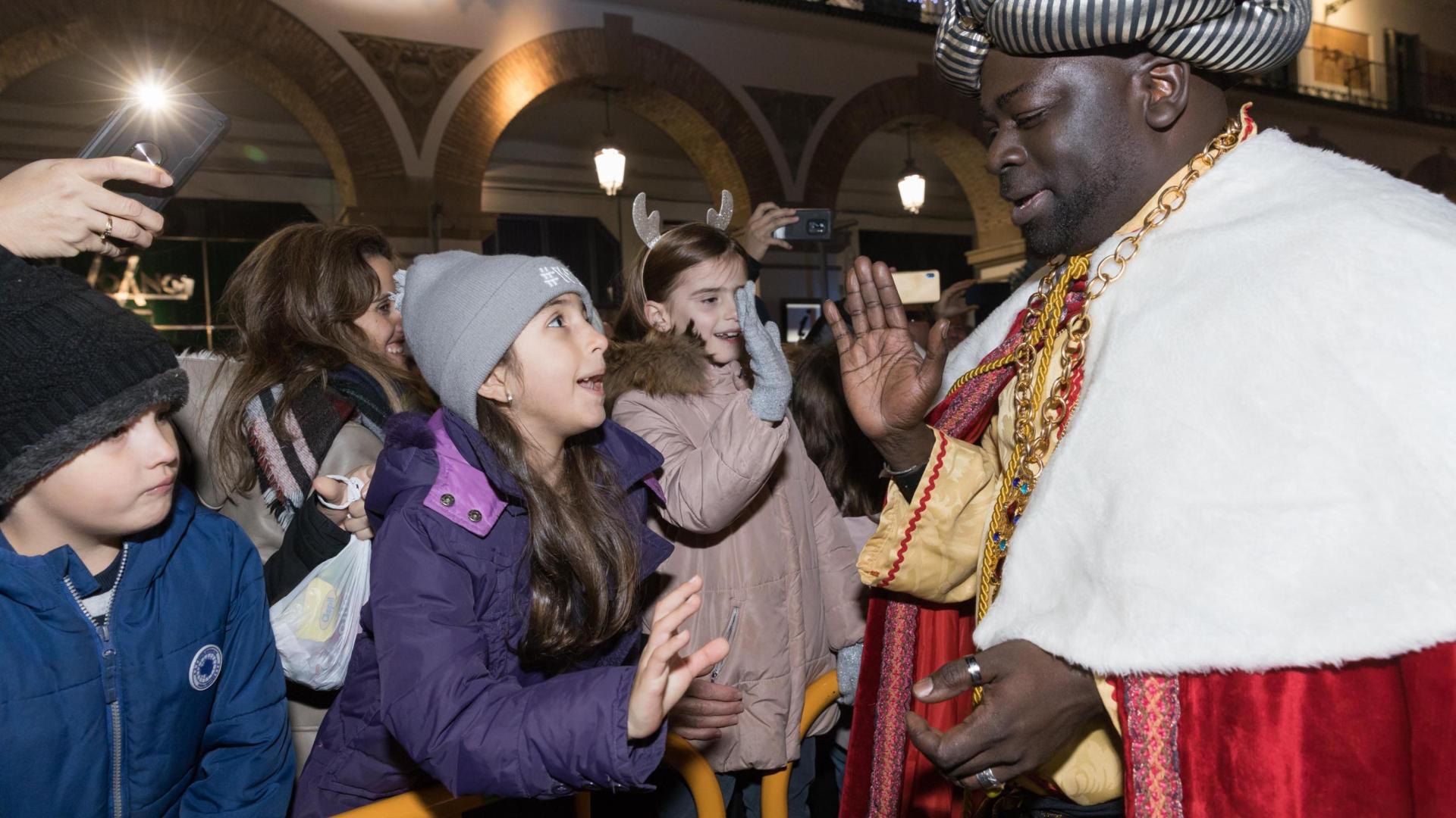 El Rey Baltasar saluda a un grupo de niños y niñas durante la última cabalgata, la de 2020