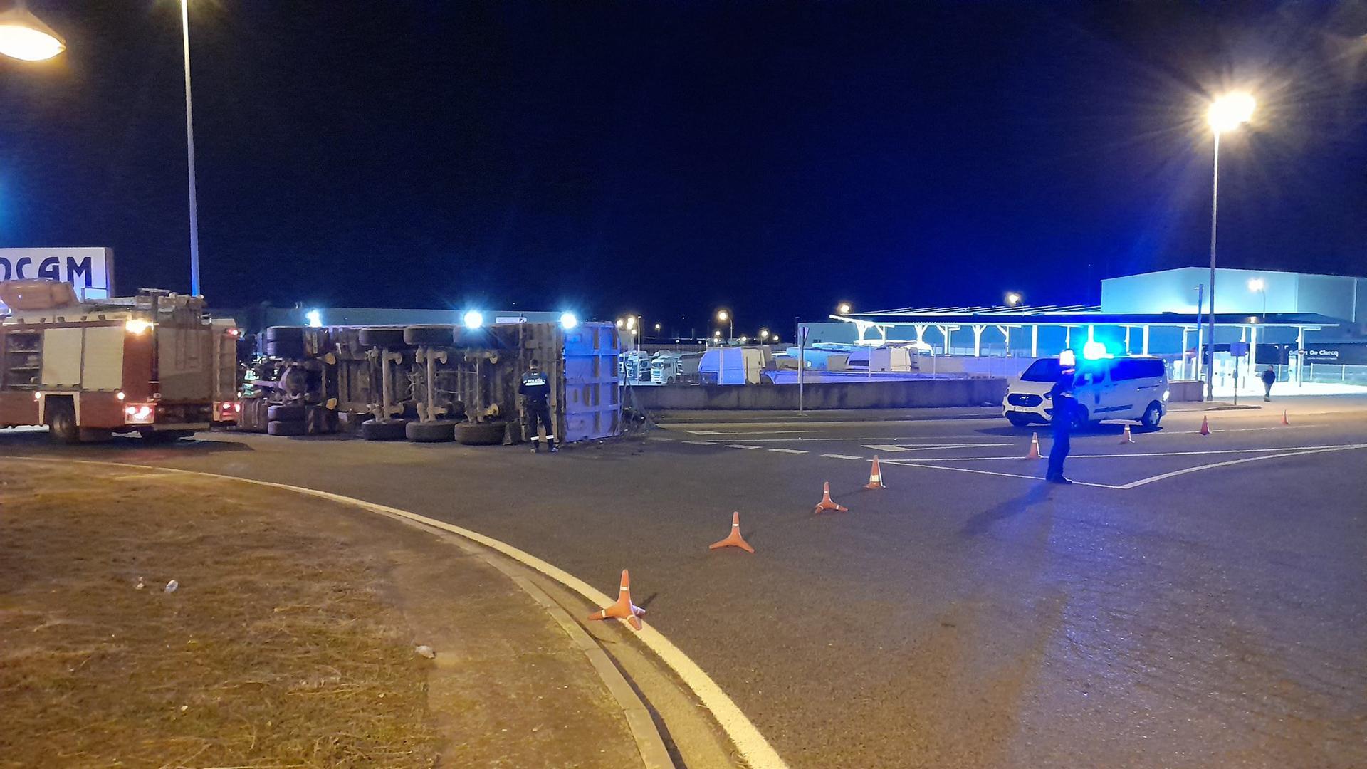 El camión volcado en la rotonda con patrullas de la Policía Local de Tudela atendiendo el incidente
