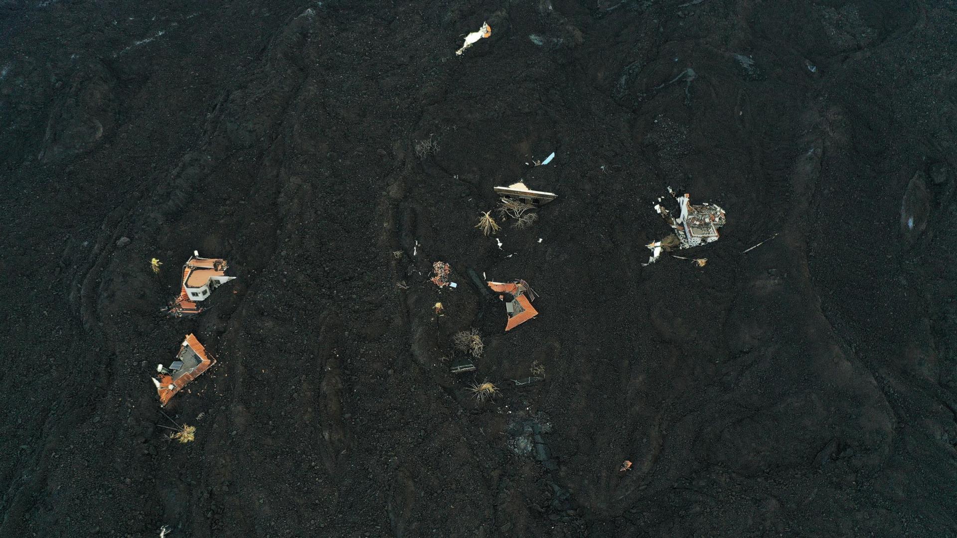 La fajana creada por la erupción del volcán Cumbre Vieja cubre algunas de las viviendas y parte de la carretera de un barrio cercano a la localidad de La Laguna