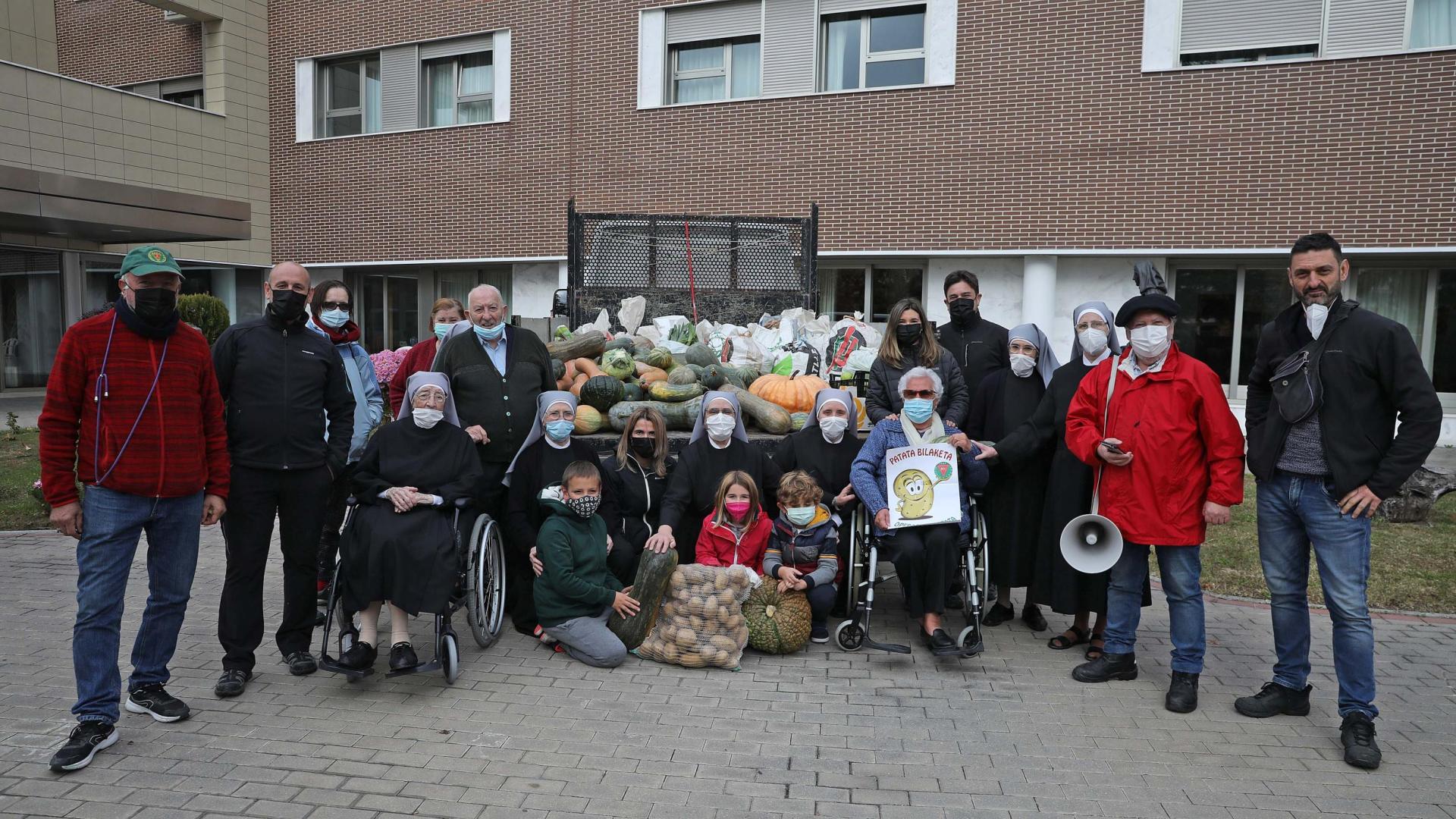 Hermanitas de los Pobres, residentes y los mozos de la peña Alegría posan con los alimentos recién llegados