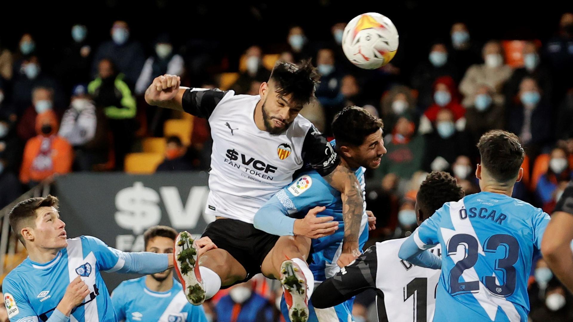 El defensa del Valencia, Omar Alderete (2i), remata el balón ante el centrocampista del Rayo Vallecano, Santi Comesaña, durante el encuentro correspondiente a la jornada decimoquinta de primera división, disputado este sábado en el estadio de Mestalla