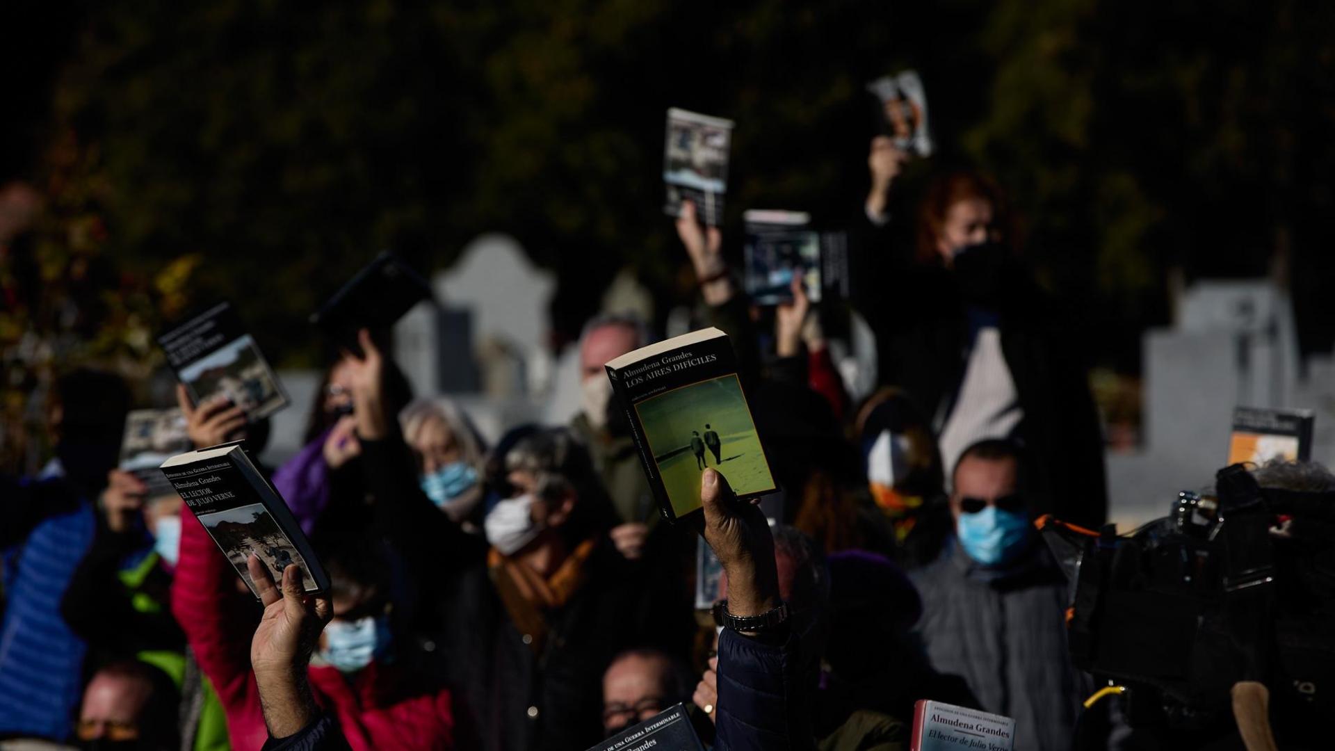 Varias personas con libros en la mano en homenaje a Almudena Grandes, asisten al entierro de la escritora en el Cementerio de La Almudena
