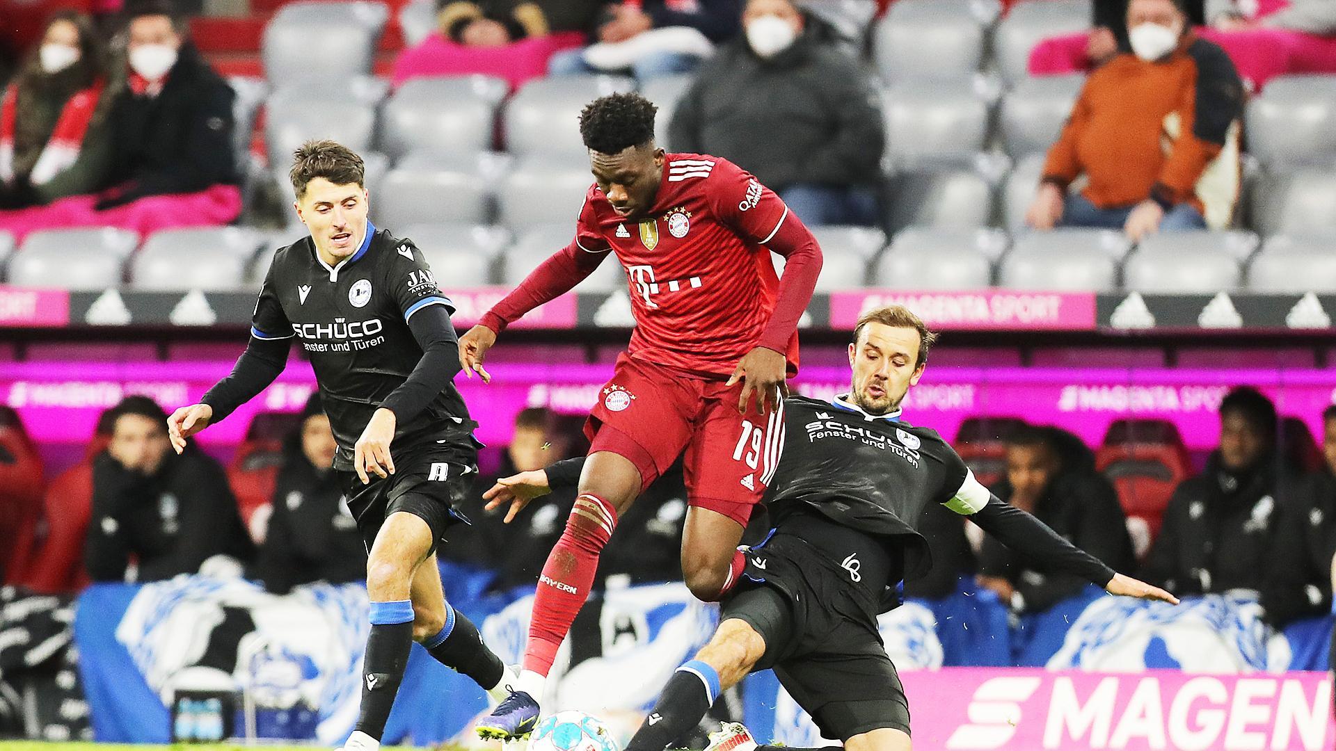 Davies, del Bayern Munich y Schopf, del Arminia Bielefeld, pelean por el balón durante el partido entre ambos equipos
