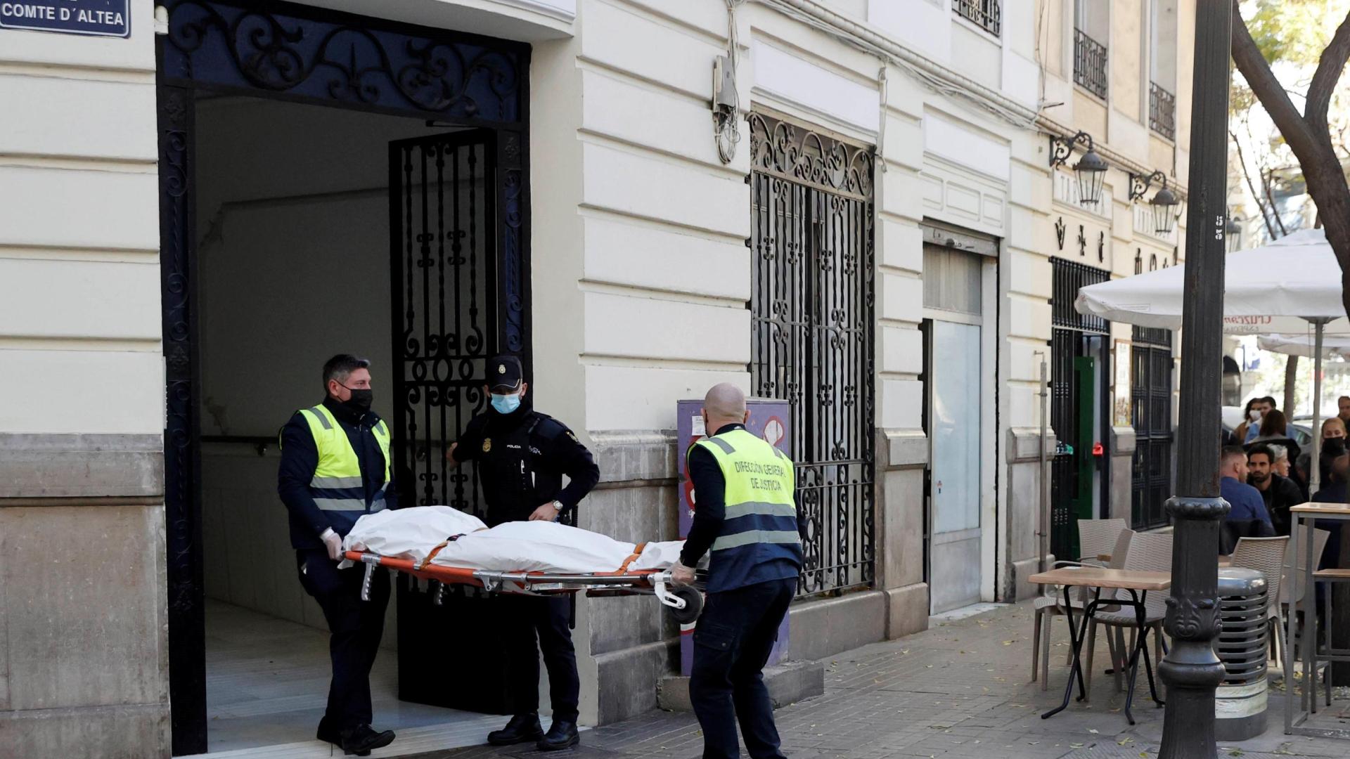 Operarios del retén fúnebre sacan el cadaver de mujer de 30 años de edad que ha sido encontrada este sábado en una vivienda de València asesinada presuntamente a manos de un hombre con el que mantenía una relación sentimental