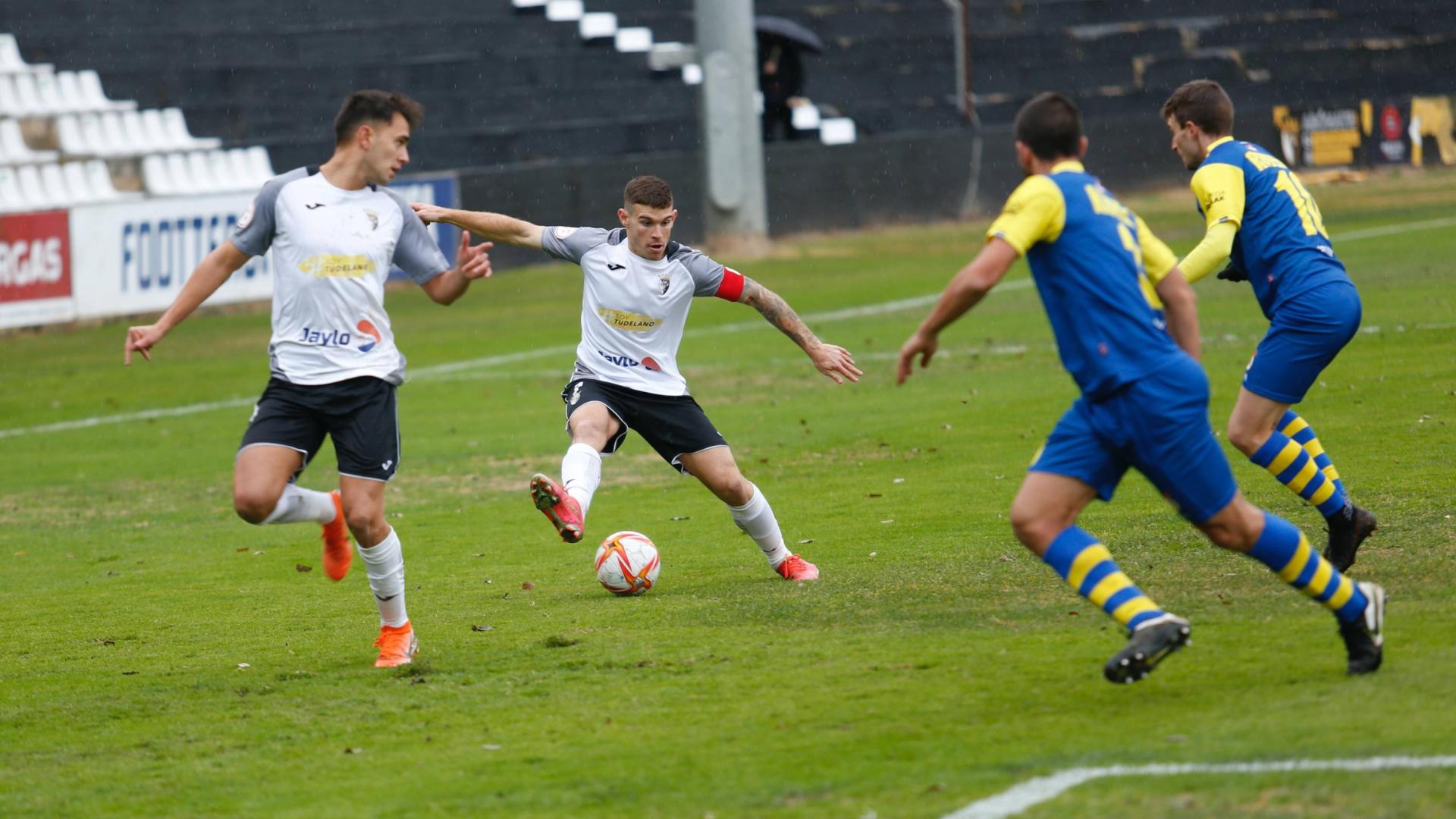Santi Samanes, con el brazalete de capitán, trata de regatear a dos defensores del Real Unión