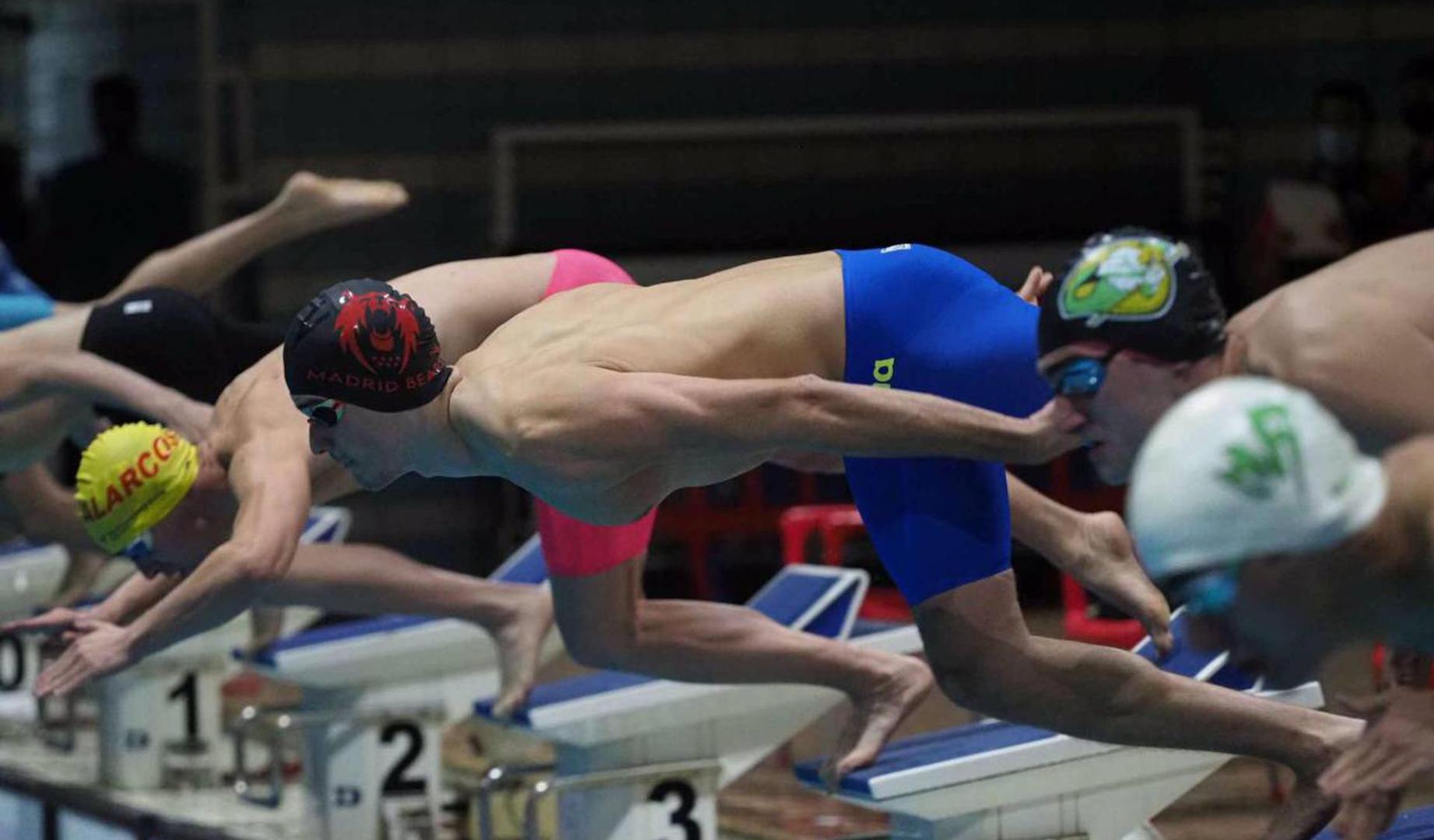 Pascual saltando, en primer plano, al agua para comenzar a competir con el gorro de su equipo, el Madrid Bears Natación