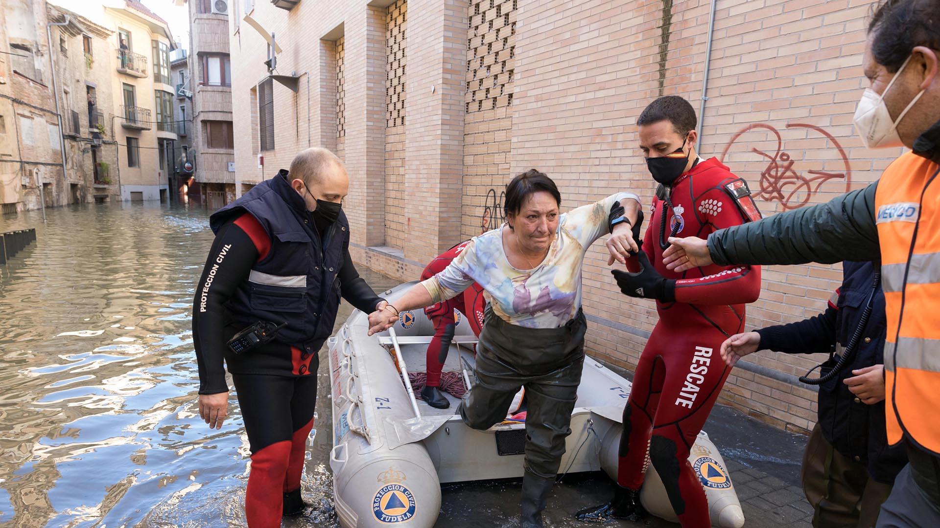 Varios voluntarios de Protección Civil ayudan a salir de la lancha a la vecina de la calle Verjas Marisol Pérez López