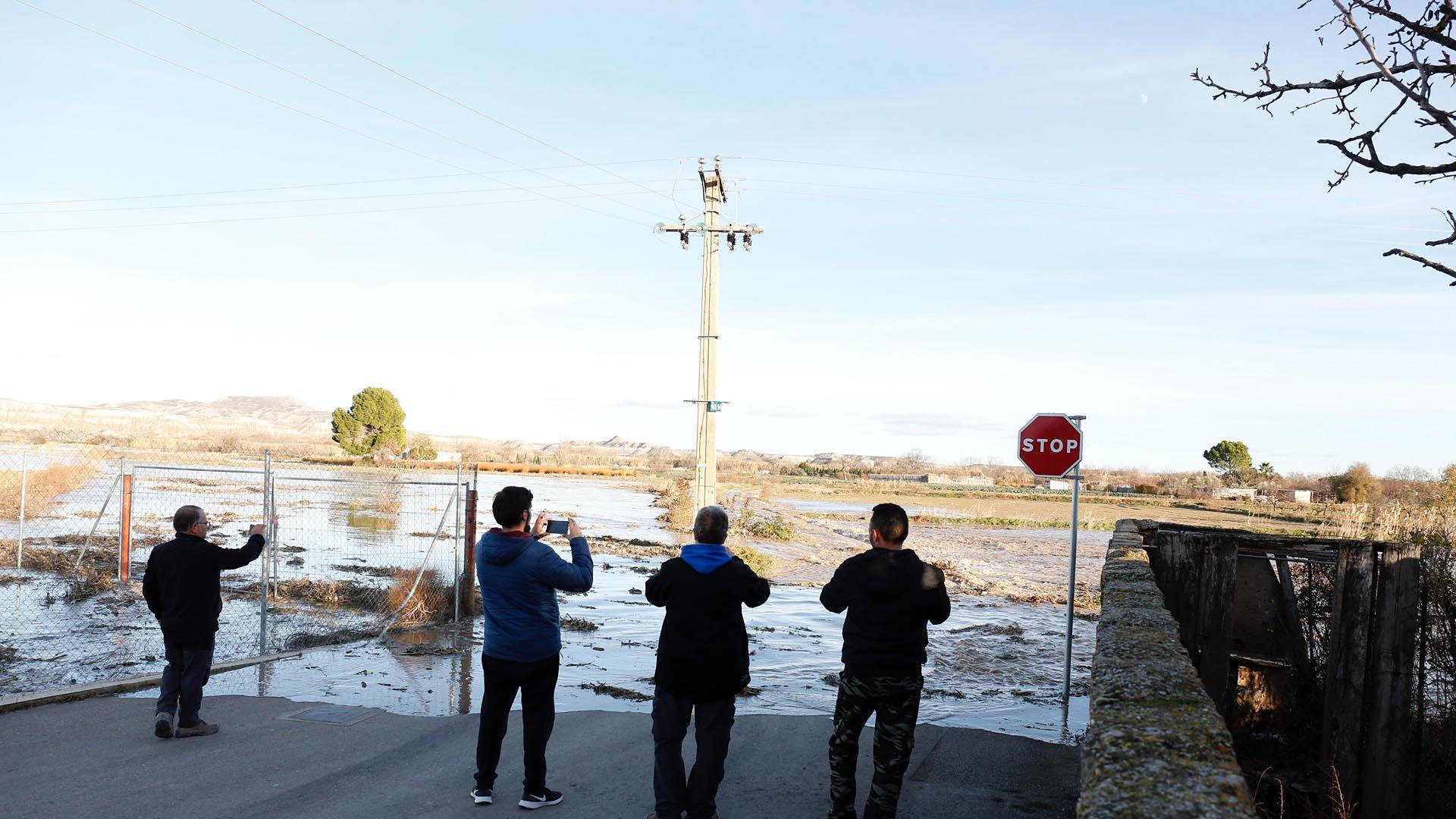Varios vecinos captan con sus móviles la crecida del río antes de que el agua entrara por la calle