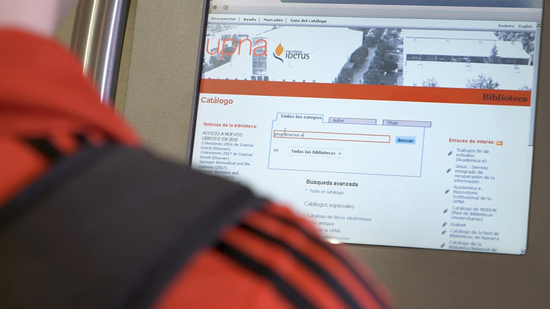 Una persona consulta el catálogo de recursos electrónicos en la biblioteca de la UPNA