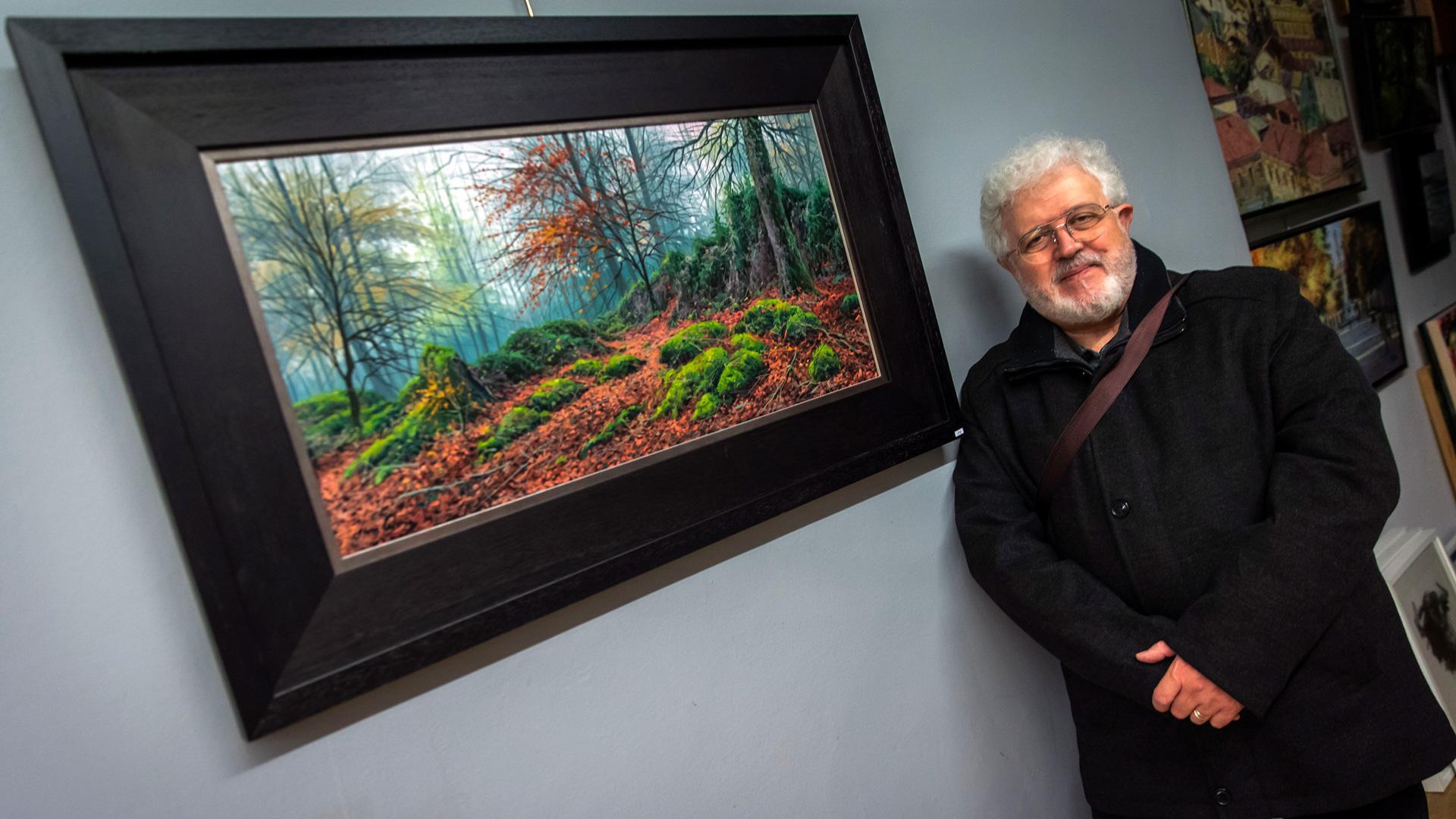 Joan Coloma posa junto a Hayedo de Urbasa, una de las obras de la exposición