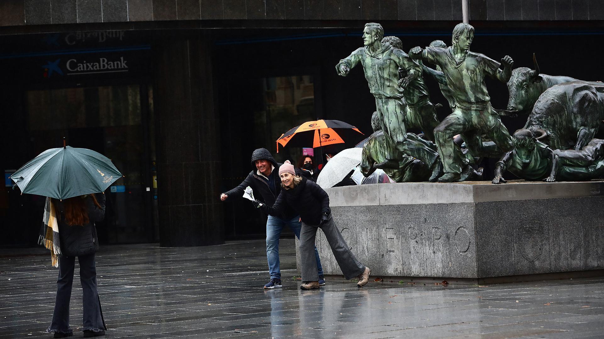 Un grupo de turistas se fotografía junto al Monumento al Encierro de Pamplona en una jornada lluviosa del pasado mes de diciembre