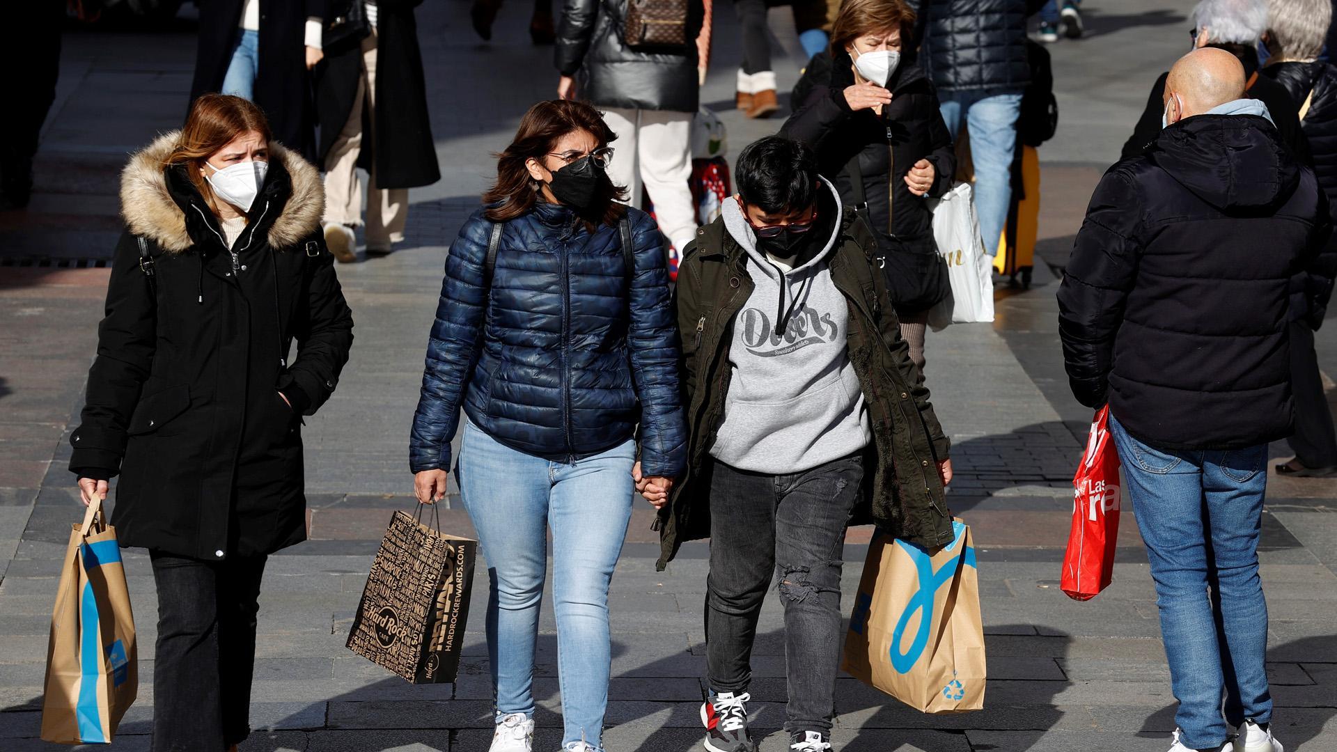 Varias personas con sus compras pasean por una zona comercial del centro de Madrid