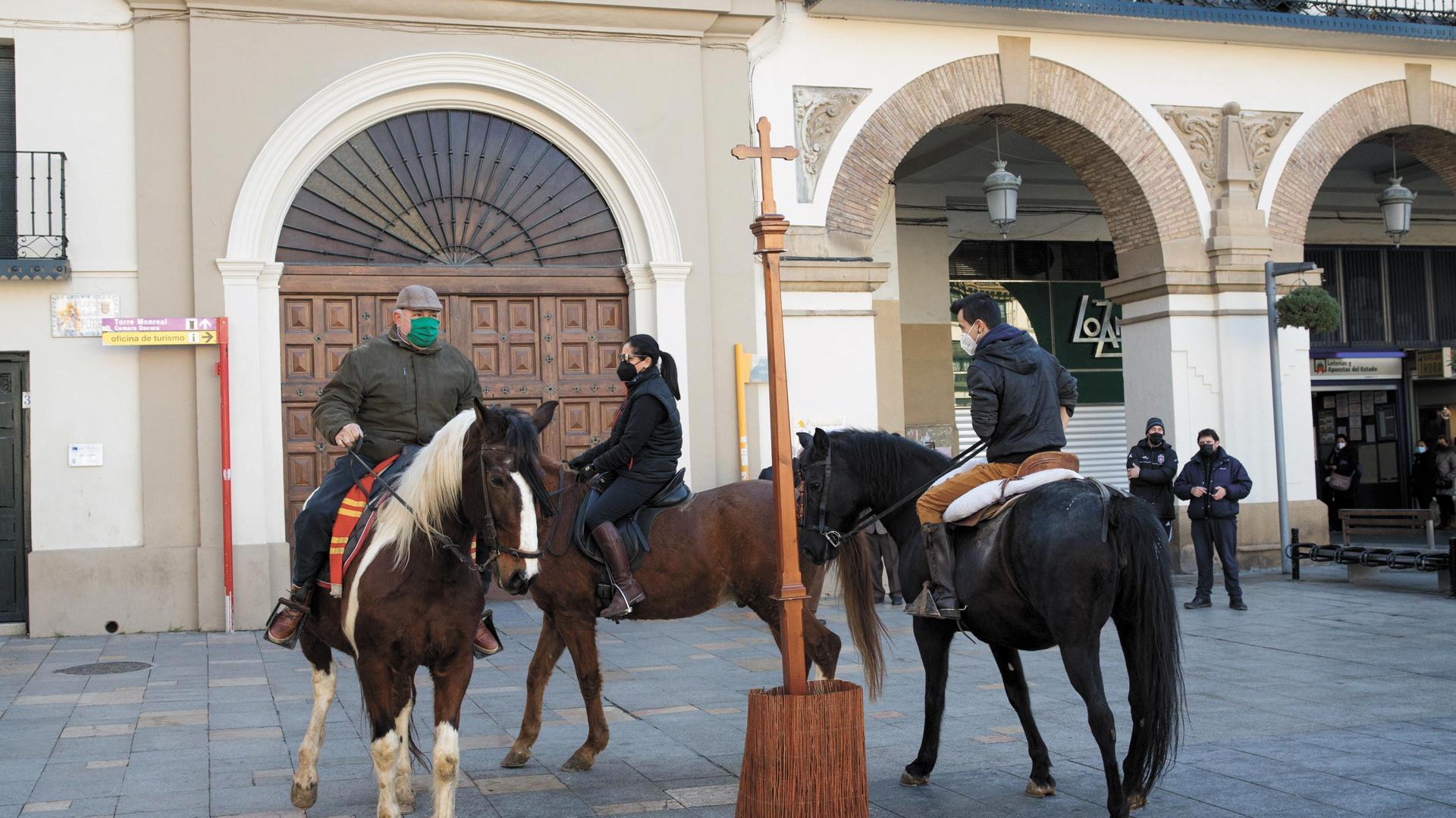 Tres jinetes proceden a dar las tres vueltas sobre sus monturas a la Cruz colocada por la Orden del Volatín en la plaza de los Fueros de Tudela