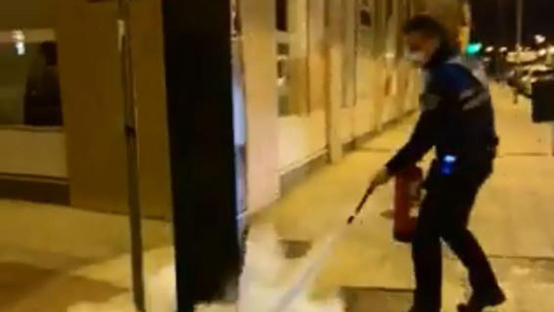 Un agente de la Policía Municipal apaga el incendio de un parquímetro