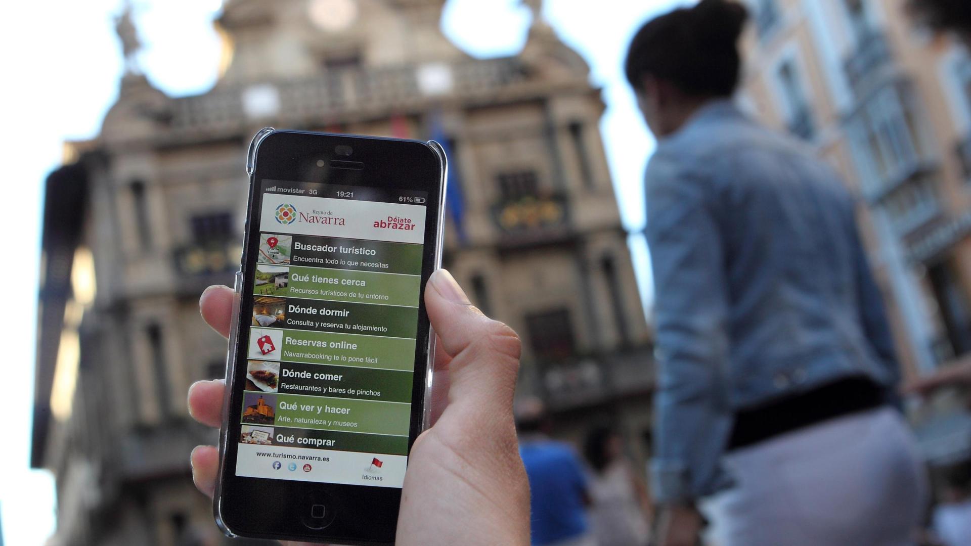 Una persona enseña una de sus aplicaciones móviles en la plaza del Ayuntamiento de Pamplona.