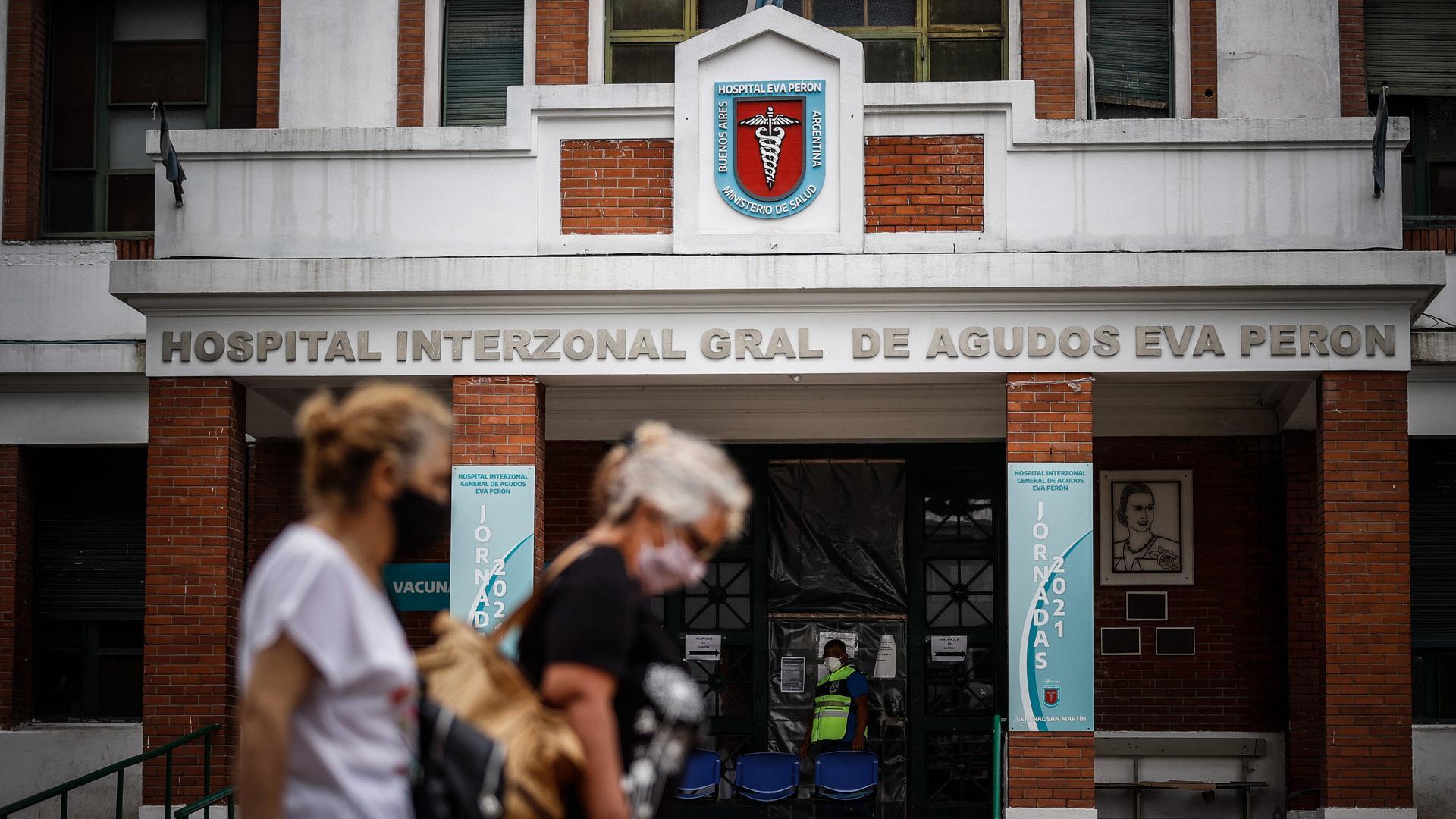 Dos personas caminan frente a la puerta del hospital de agudos, Argentina