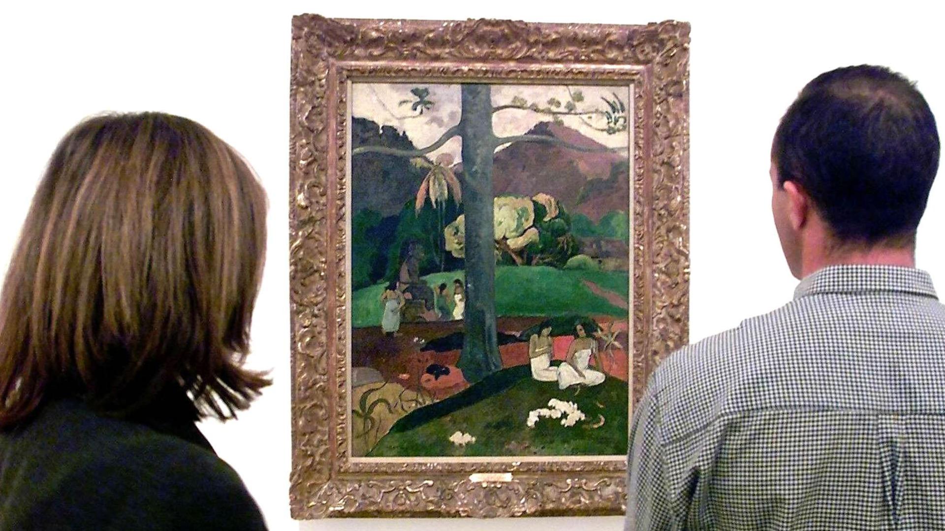 Dos visitantes observan el cuadro "Mata Mua" de Paul Gauguin