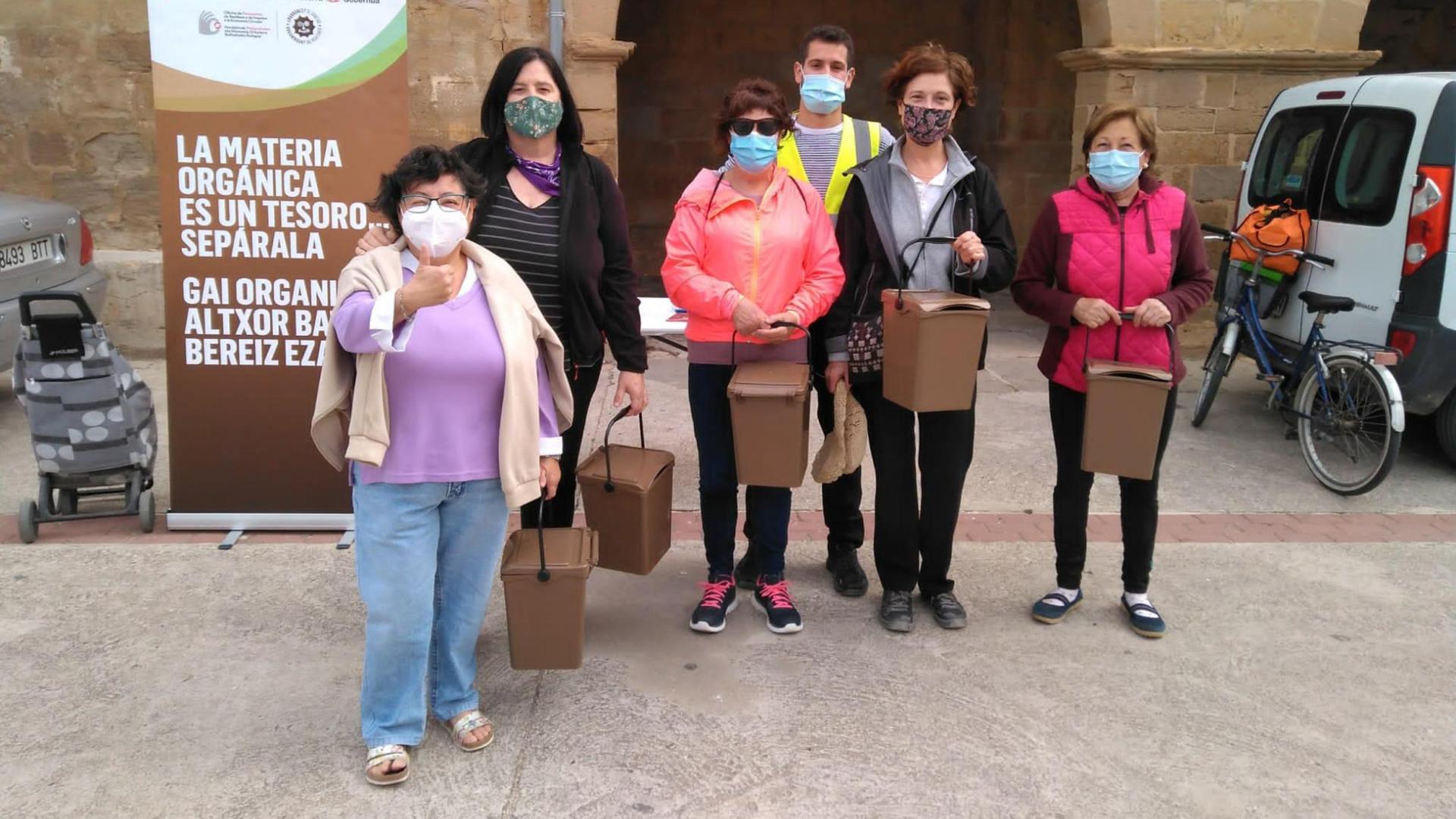 Un grupo de vecinos con el contenedor marrón para depositar la materia orgánica