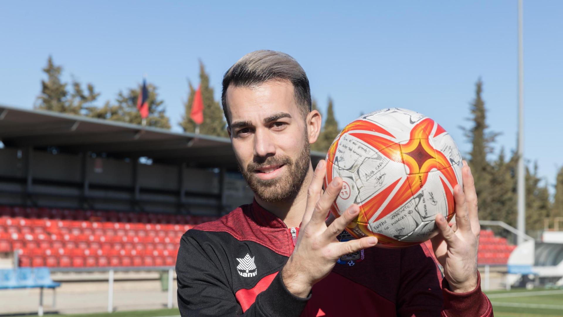 Sergio Sanz, capitán del Corellano, posa en el Ombatillo sujetando el balón firmado por su compañeros tras su triplete.