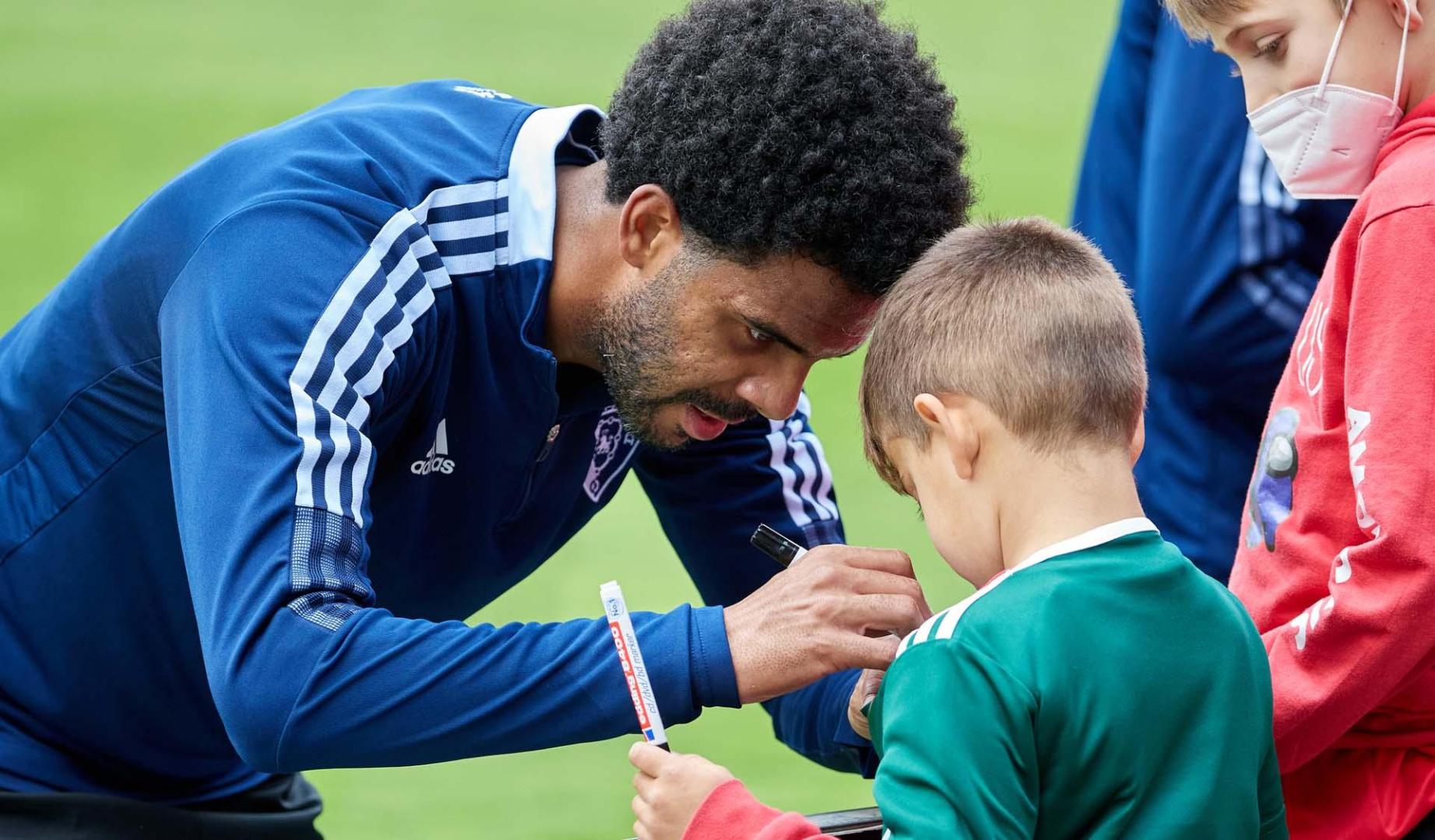 Ramalho estampa la firma en la camiseta del niño