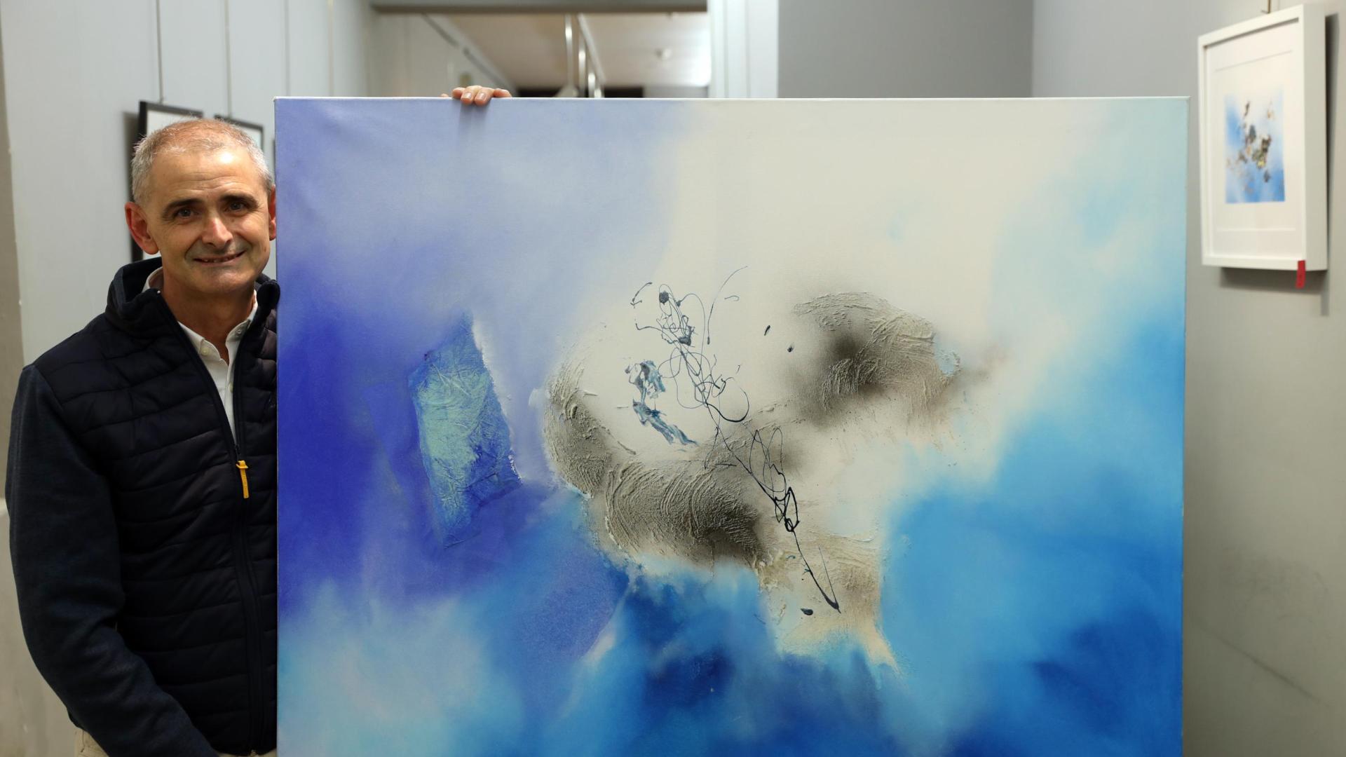 El artista Antonio Peña posa en la galería Michel Menéndez junto a la obra titulada Destrucción azul I.