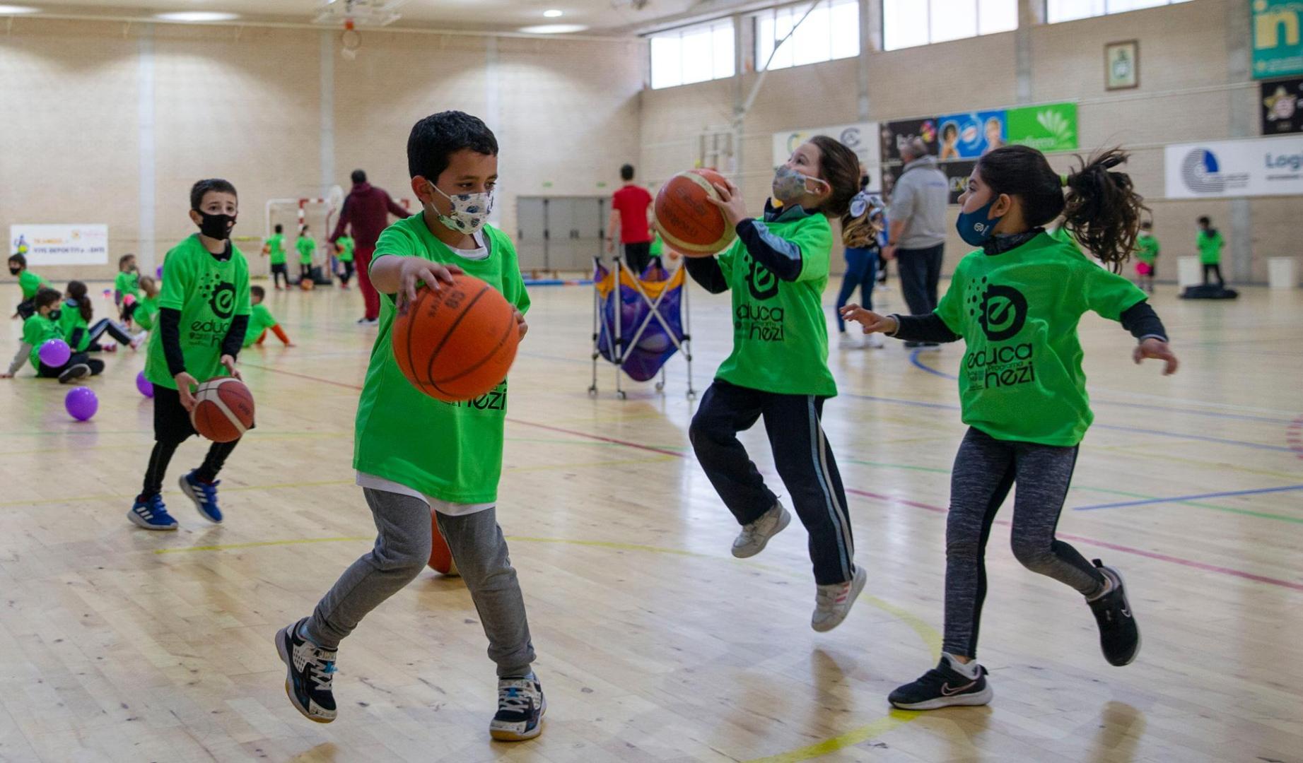 Un grupo de escolares practica el tiro a canasta