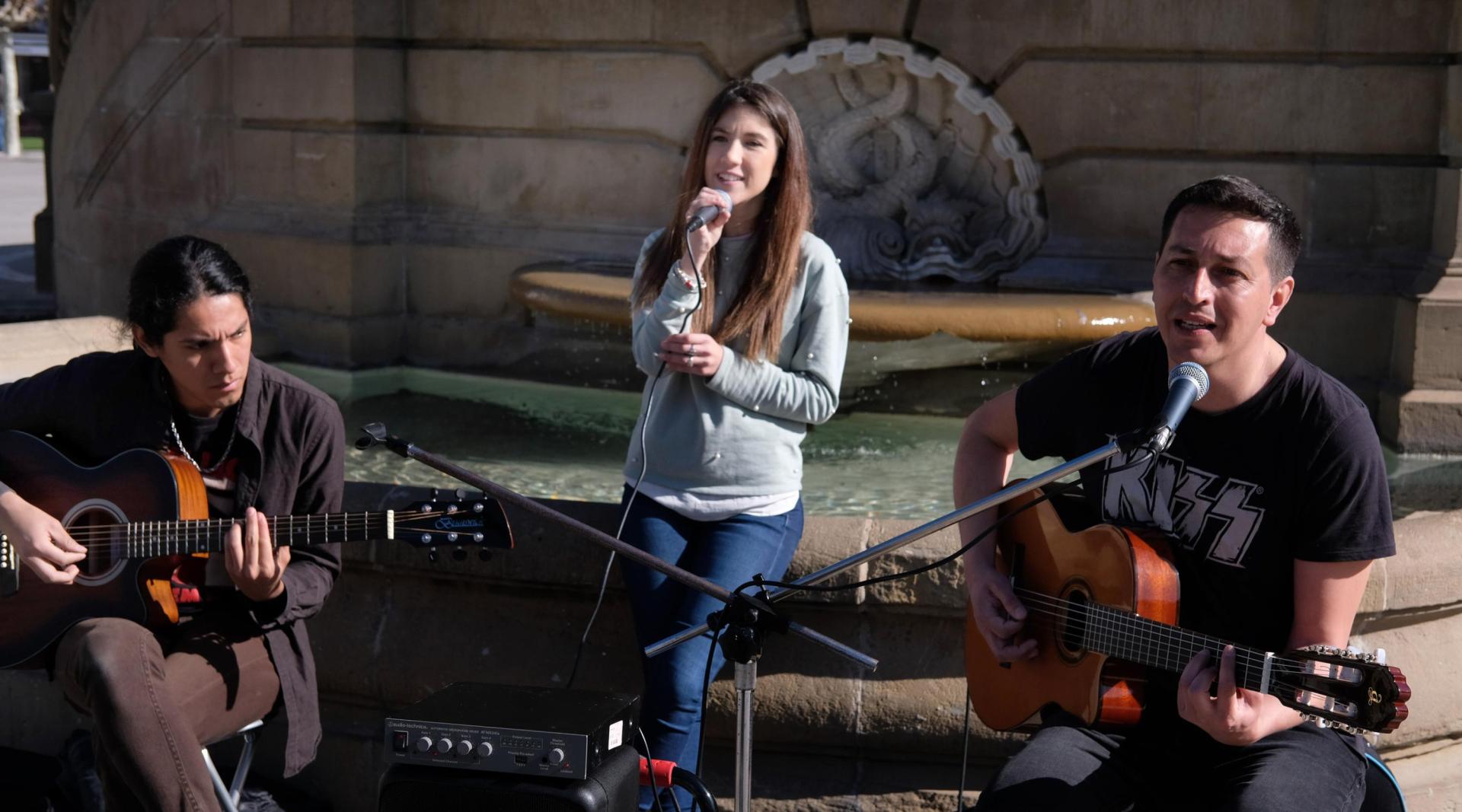 De izquierda a derecha: Milo Valenzuela (41 años), Israel Garate (25)  y Olaia Bernabé (23), integrantes de la Orquesta Meteoro 2.0, en la Plaza del Castillo de Pamplona.