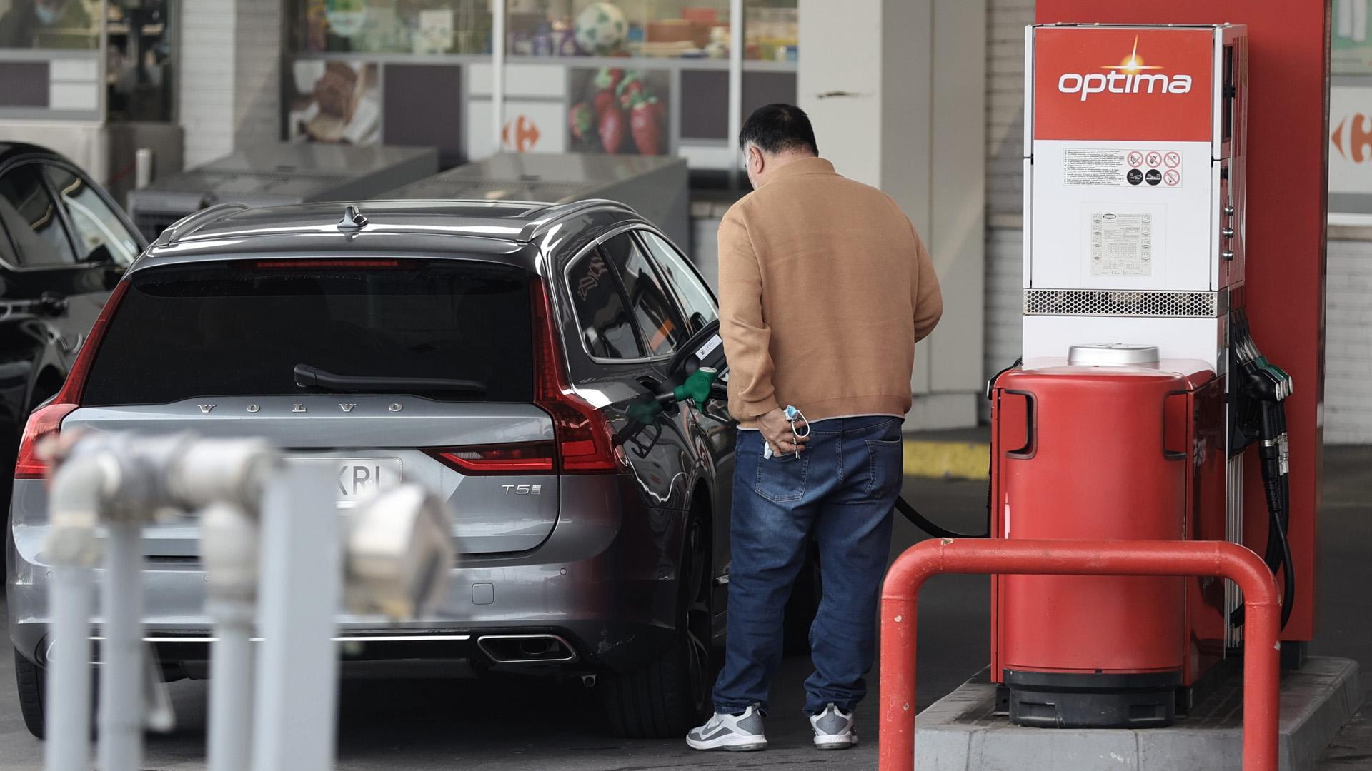 Una persona reposta combustible una gasolinera