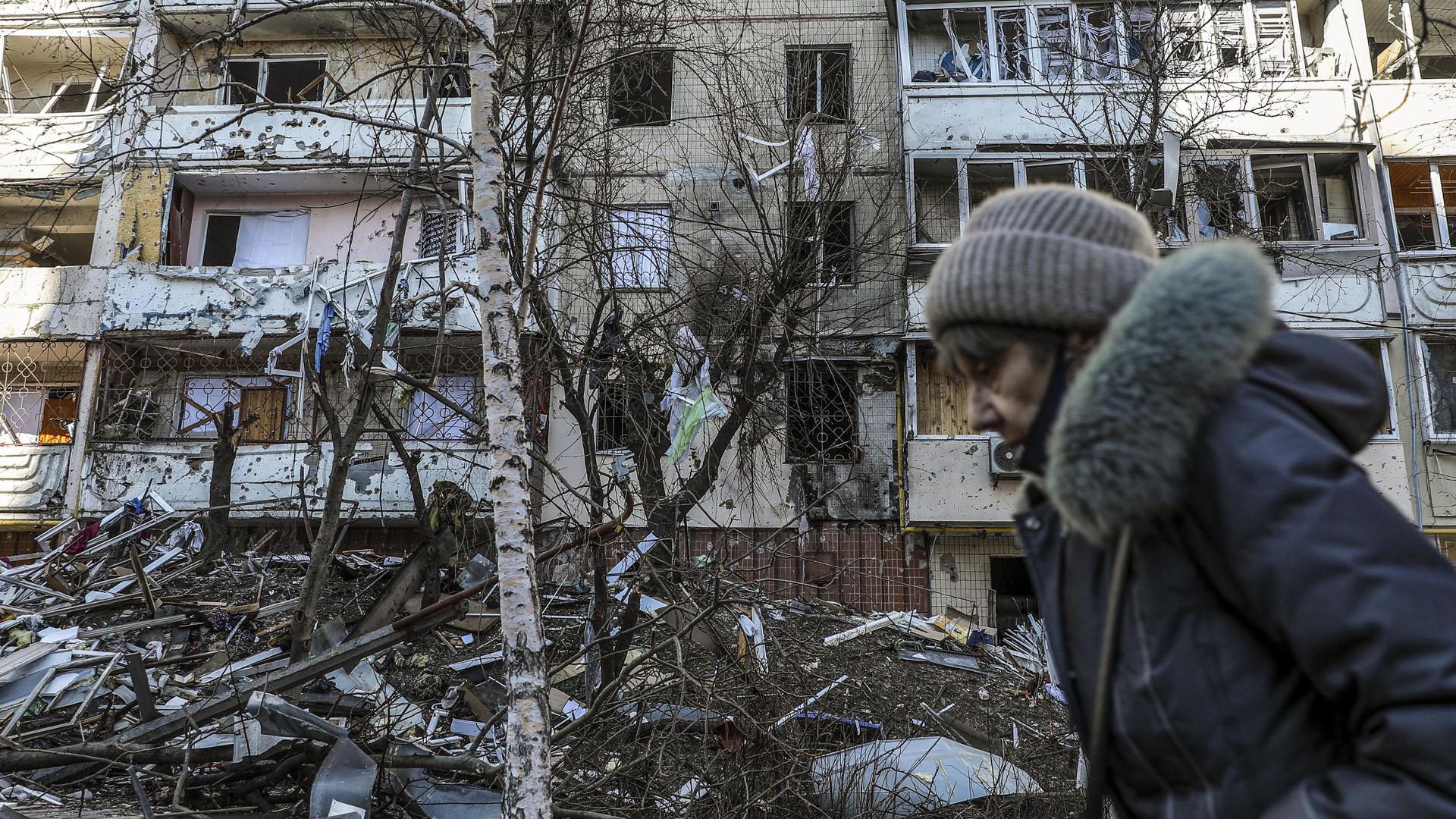 Una mujer pasa por delante de un edificio dañado por los bombardeos en Kiev