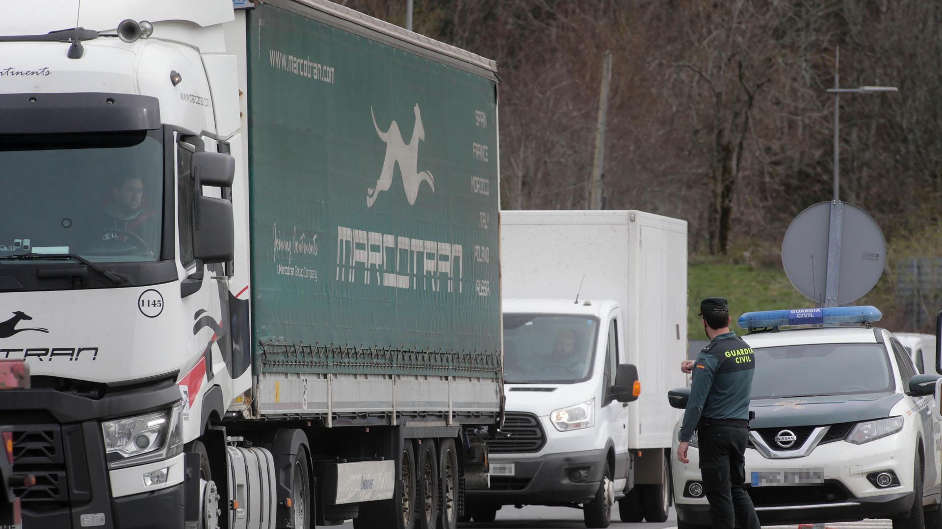 Un agente de la Guardia Civil dirige el tráfico de camiones en dirección a la Autovía A6, en Lugo