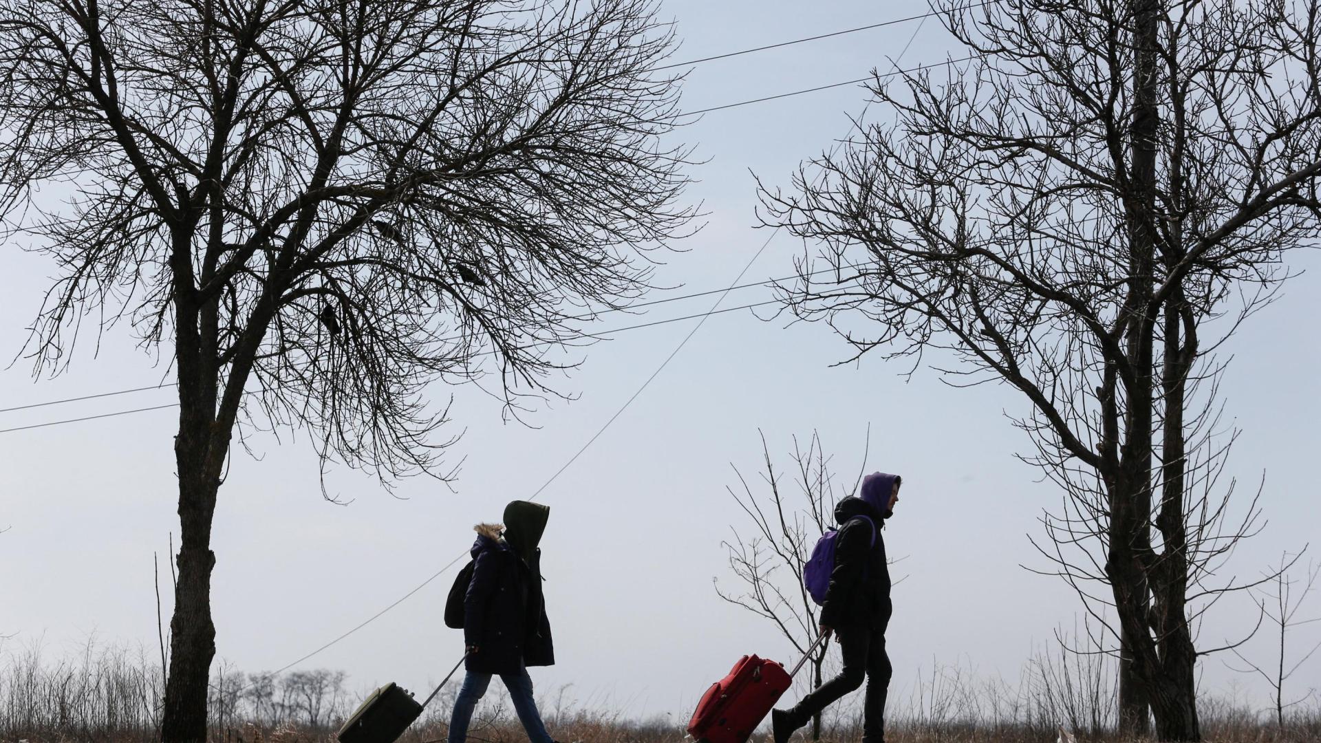 Refugiados caminan por una carretera saliendo de Mariupol