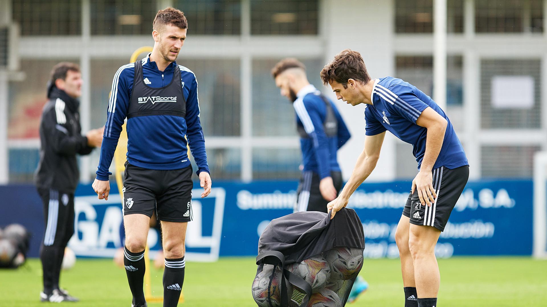 Oier e Iñigo Pérez cogen balones durante el entrenamiento de este lunes,21 de marzo