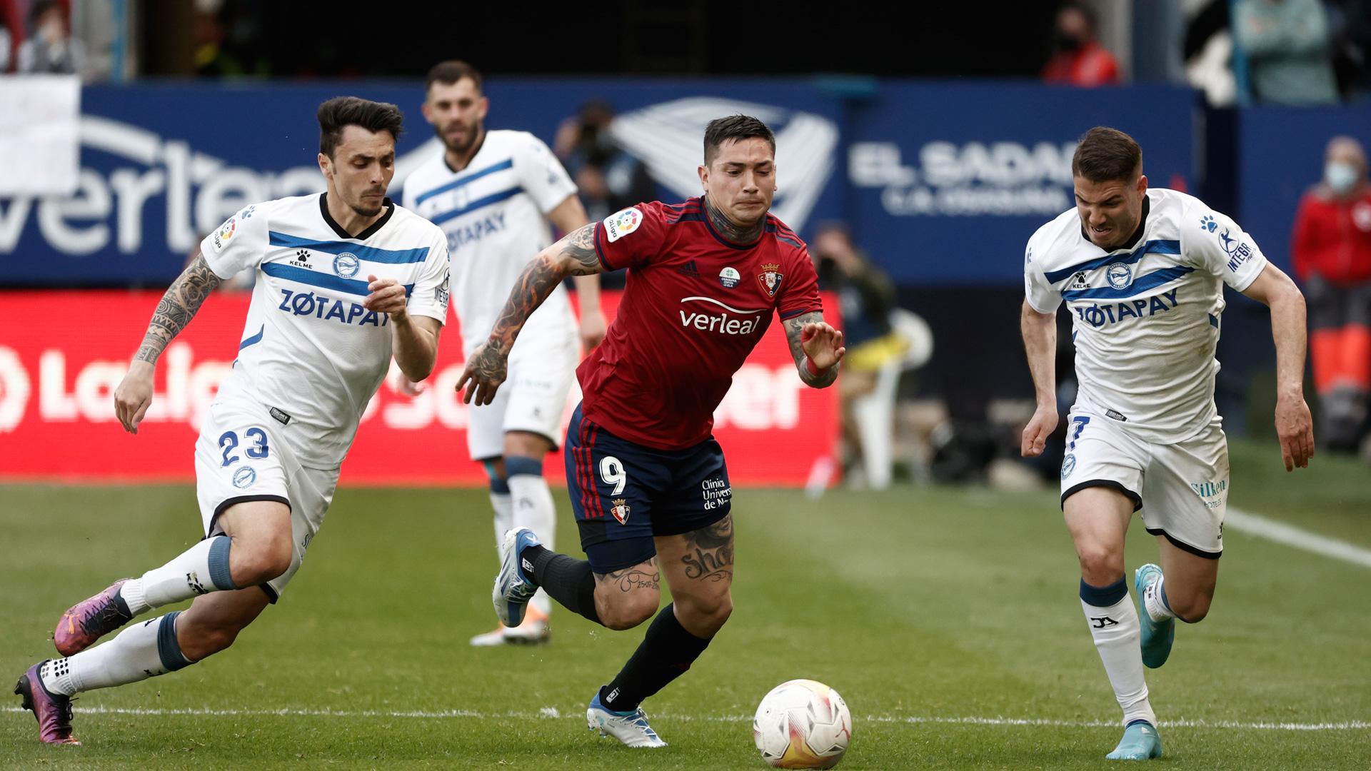 El delantero argentino del Osasuna, Chimy Ávila lucha por el balón con el defensa Ximo Navarro del Alavés