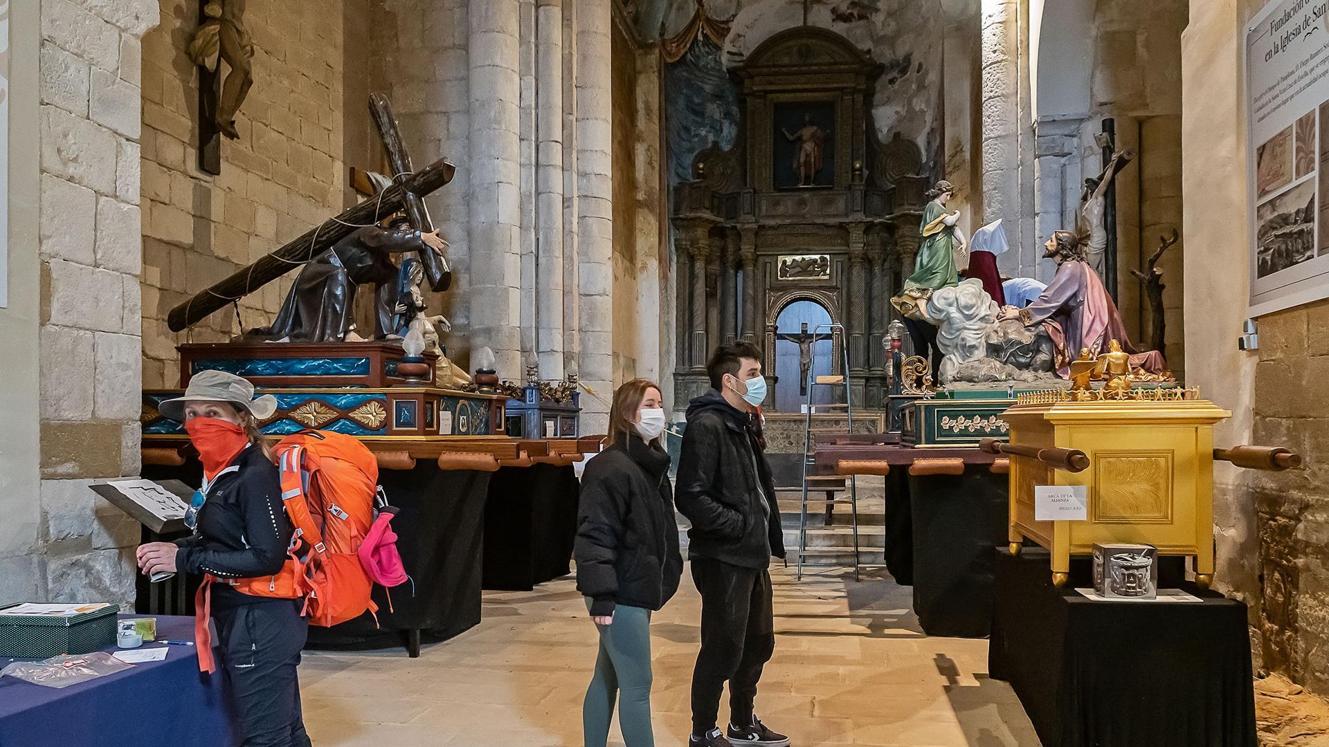 Visitantes ayer en el Santo Sepulcro y, a la derecha, el paso que hoy no saldrá en la procesión