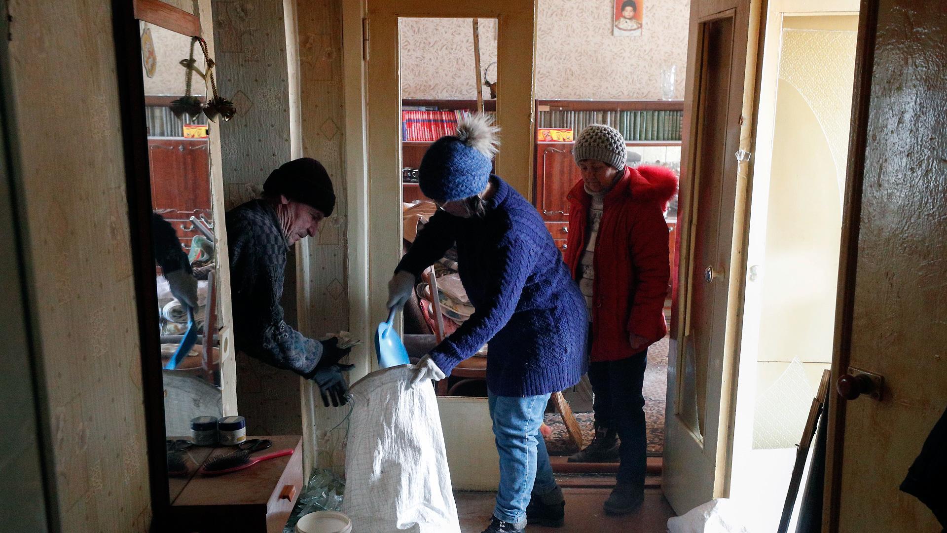 Tres personas limpian su vivienda en la localidad de Makariv, cerca de Kiev