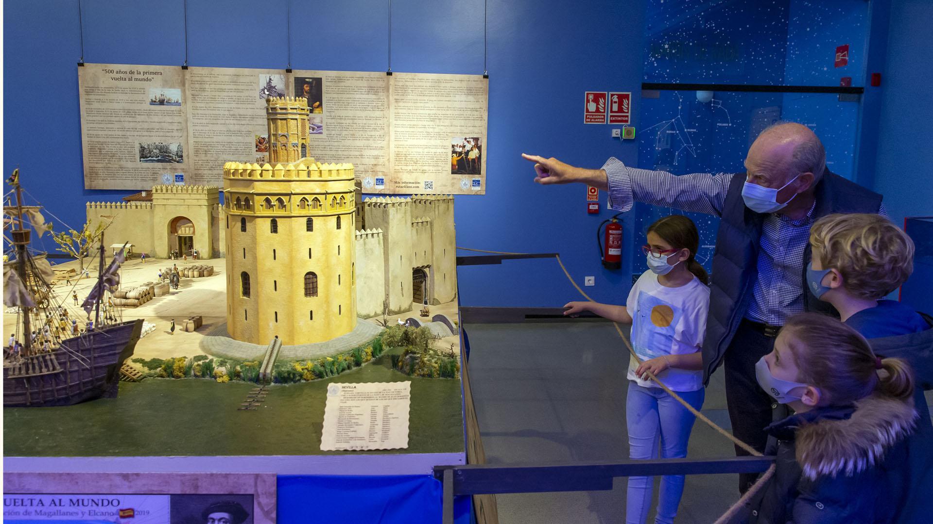Varios visitantes contemplan la recreación del puerto de Sevilla en 1522, año en que la expedición regresó con 18 supervivientes a bordo de la nao Victoria