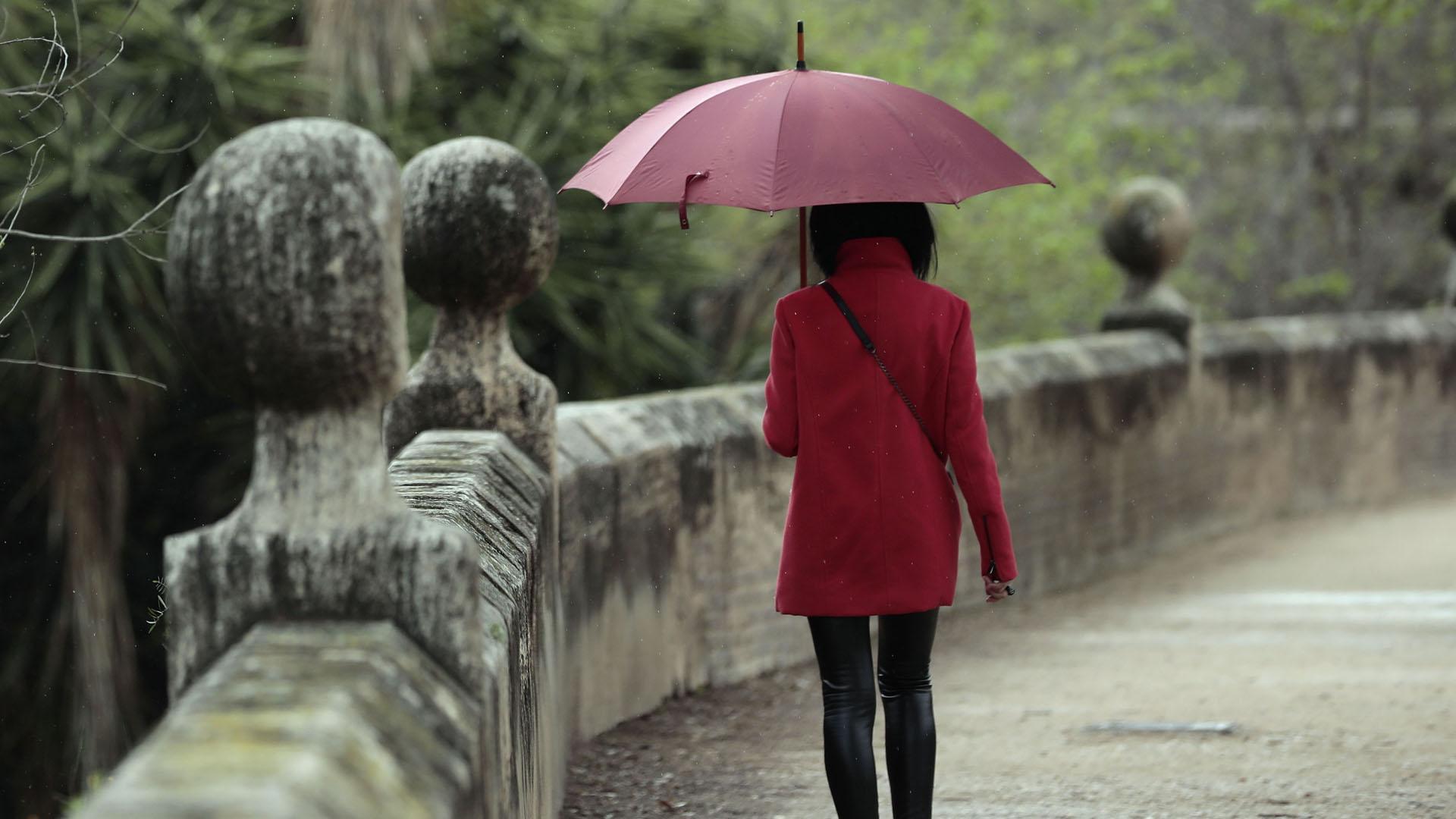 Una persona pasea bajo la lluvia.
