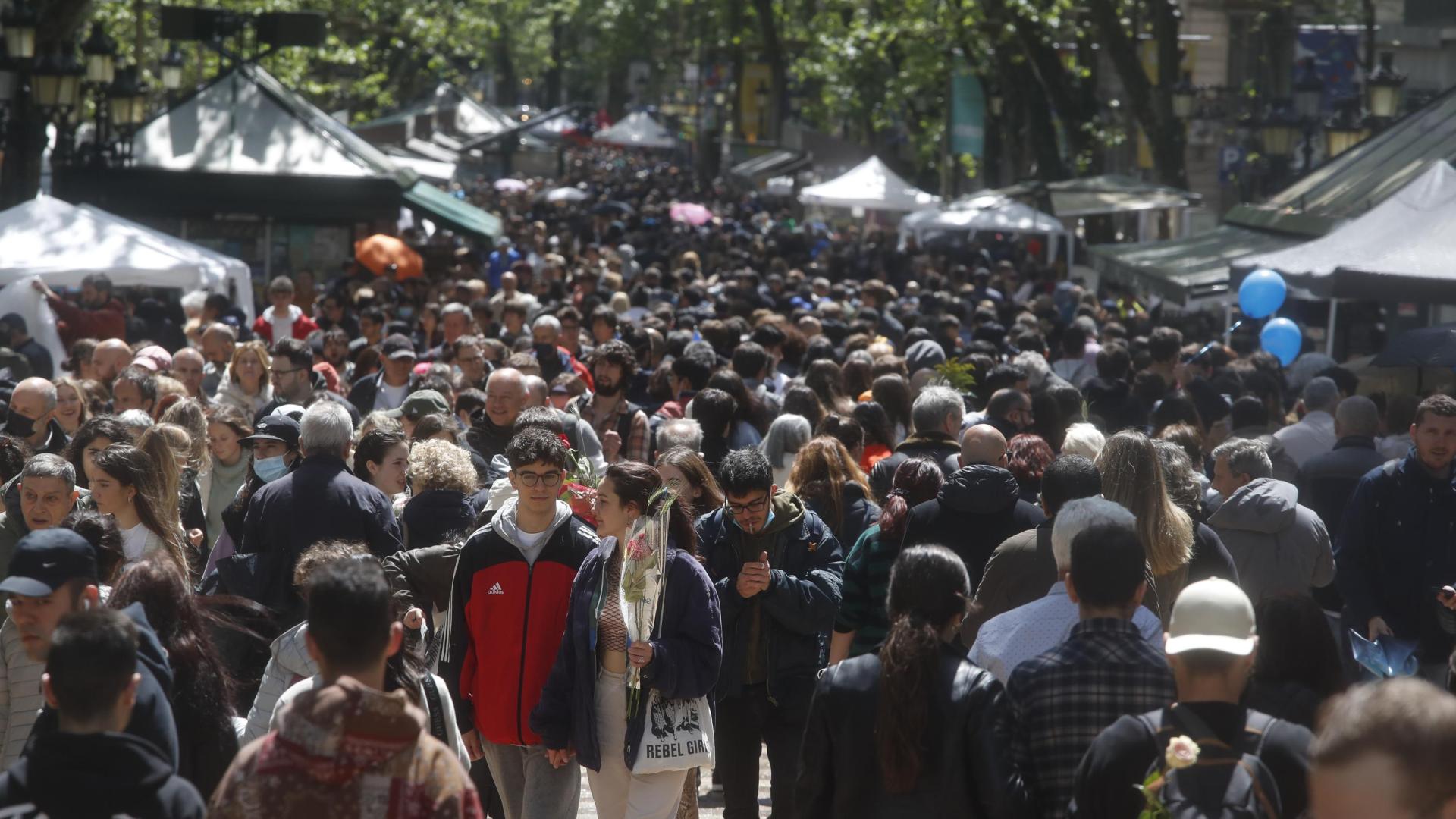 Ciudadanos visitan de manera multitudinaria las casetas de venta de libros con motivo de la celebración de Sant Jordi en Barcelona este sábado