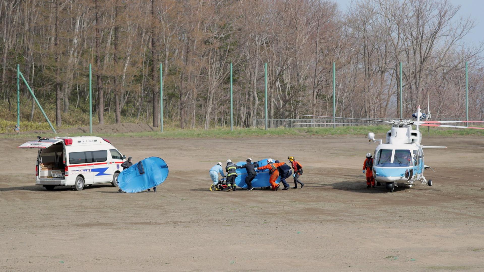 Efectivos sanitarios trasladan a parte de los pasajeros localizados de la embarcación turística accidentada en Japón