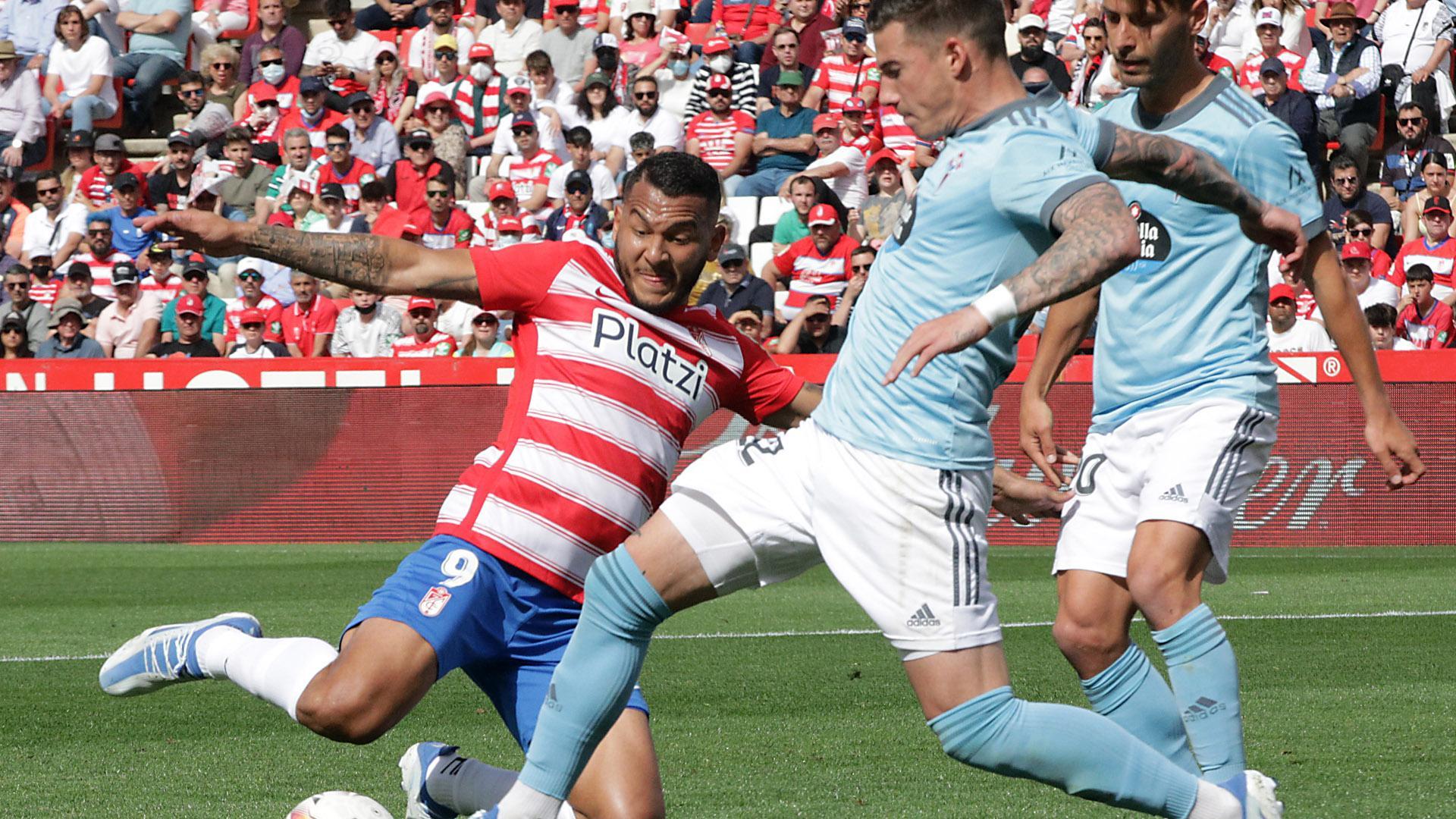 Luis Suárez, delantero del Granada, se lanza al suelo para pelear por el balón con un jugador del Celta