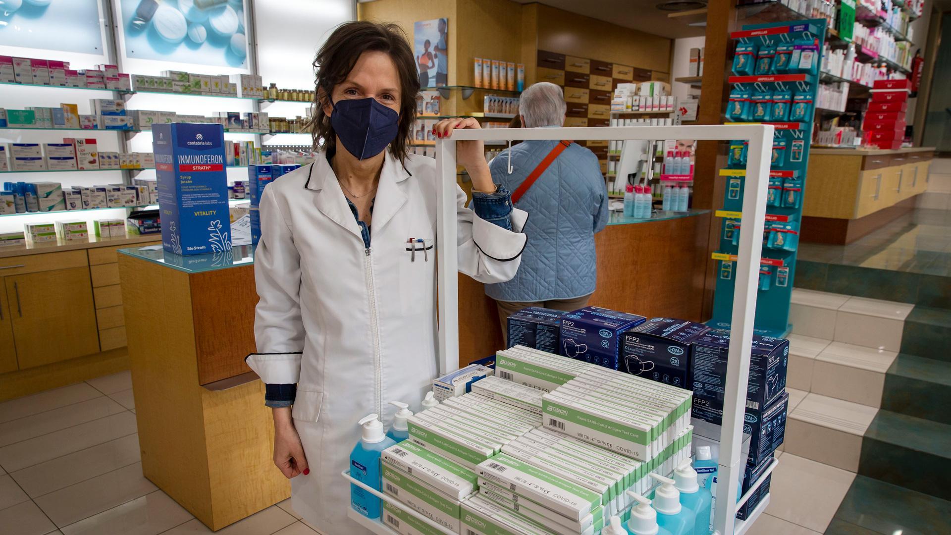 La farmacéutica Cristina Iriarte Iribarren en su botica, junto a un mostrador con test de antígenos