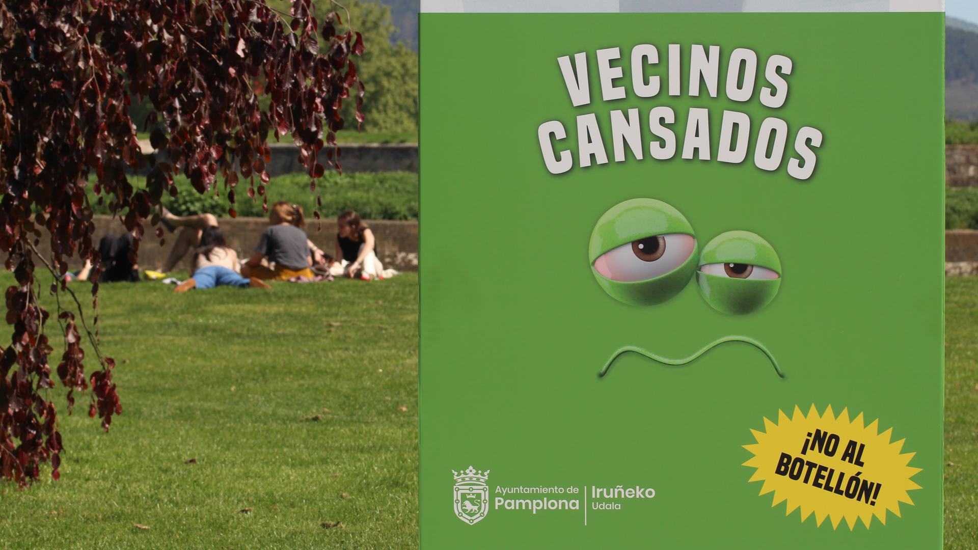 Un grupo de jóvenes descansa en la hierba de la Vuelta del Castillo a unos metros de la botella gigante para prevenir botellones