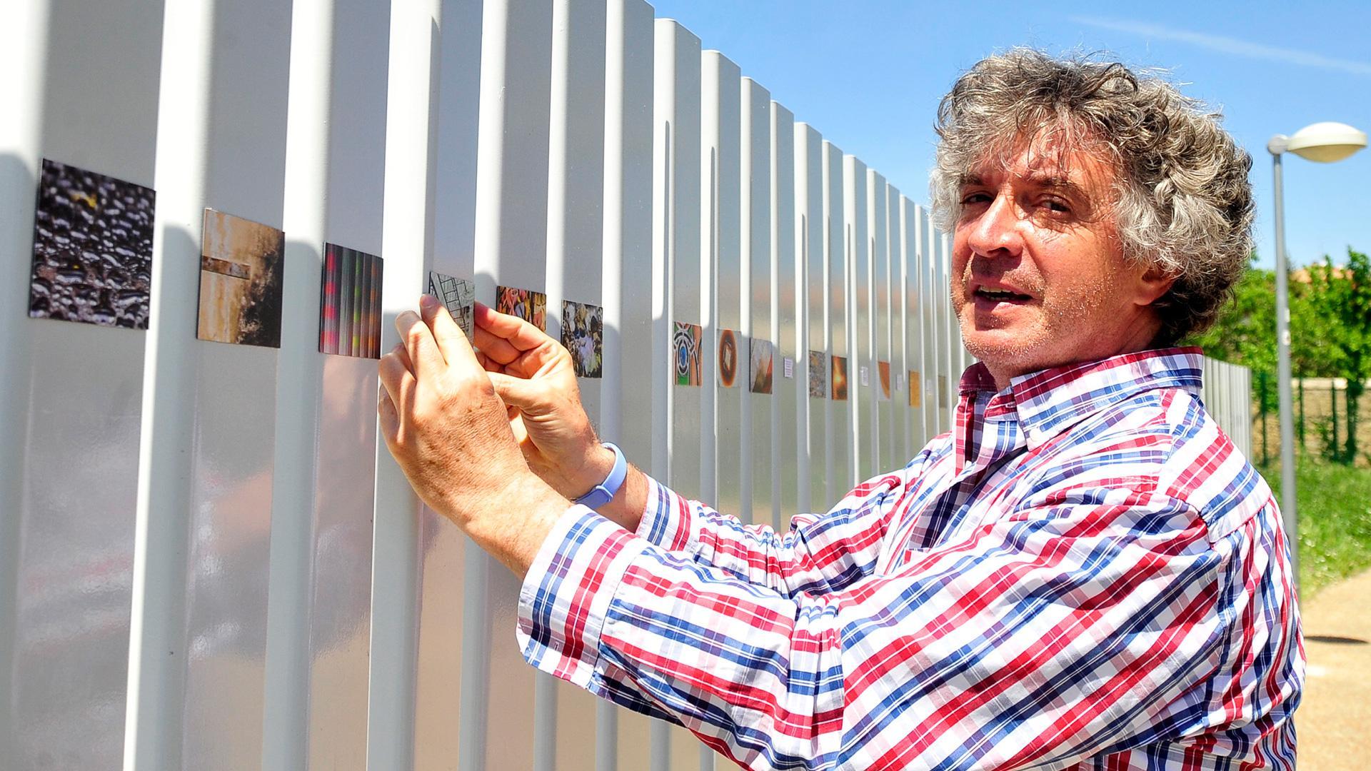 Atxu Ayerra junto a las instantáneas que expone estos días en el paseo de la República de Tafalla
