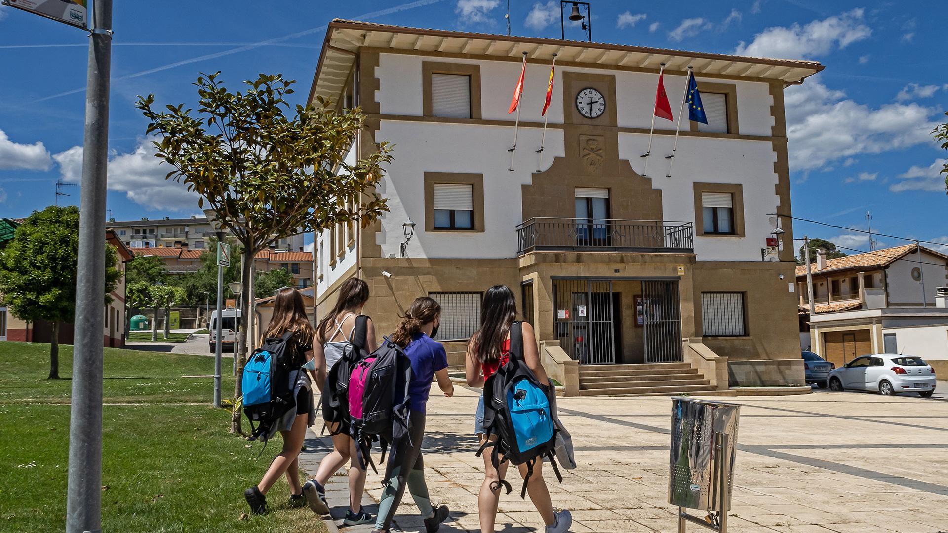 Un grupo de jóvenes camina ante la casa consistorial de Ayegui a su llegada del instituto
