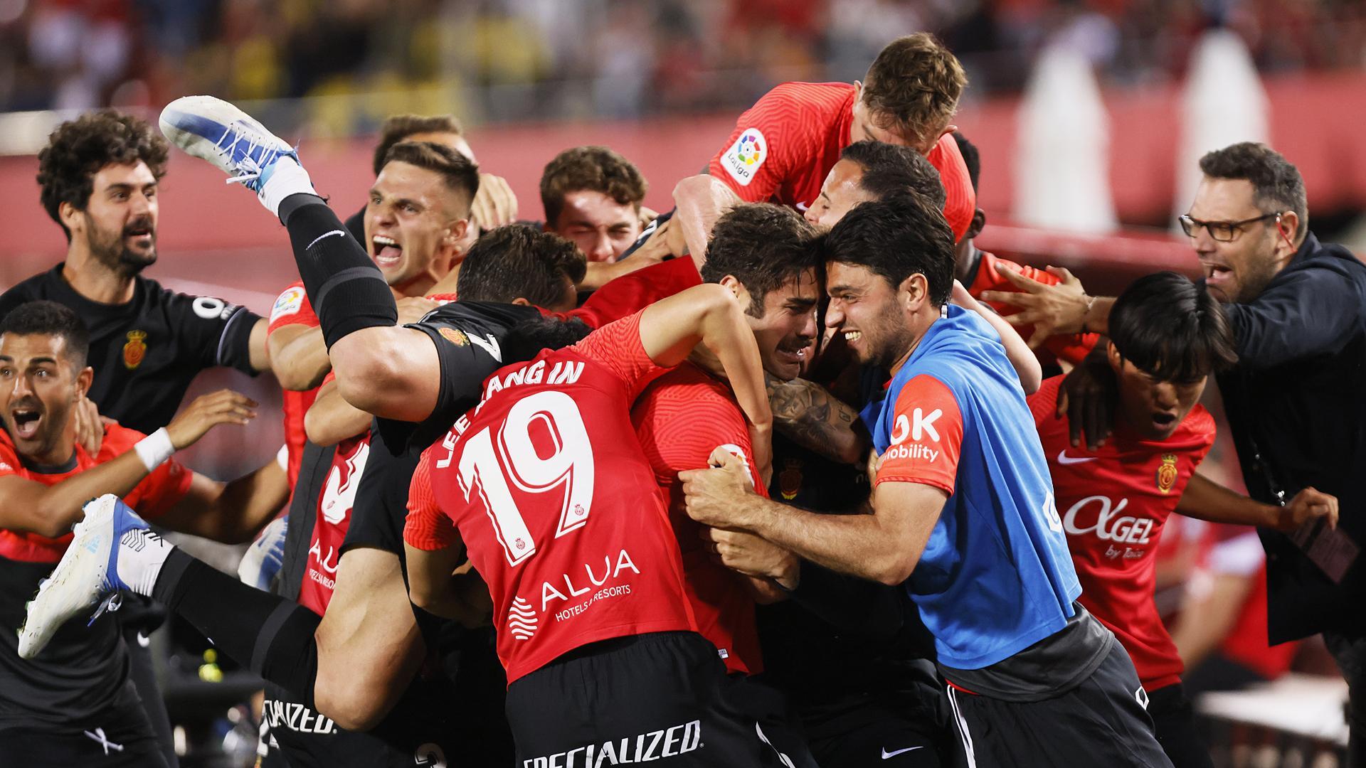 Los jugadores del Mallorca hacen una piña tras el gol postrero de Abdón Prats contra el Rayo que les hace tener en sus manos la permanencia