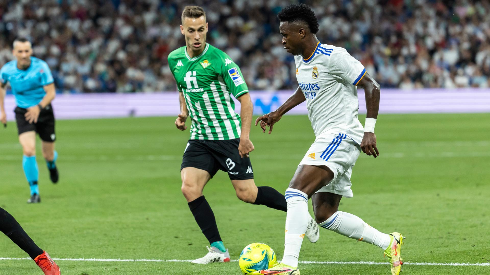 Vinicius Junior juega un balón ante Sergio Canales, del Betis en el Bernabéu