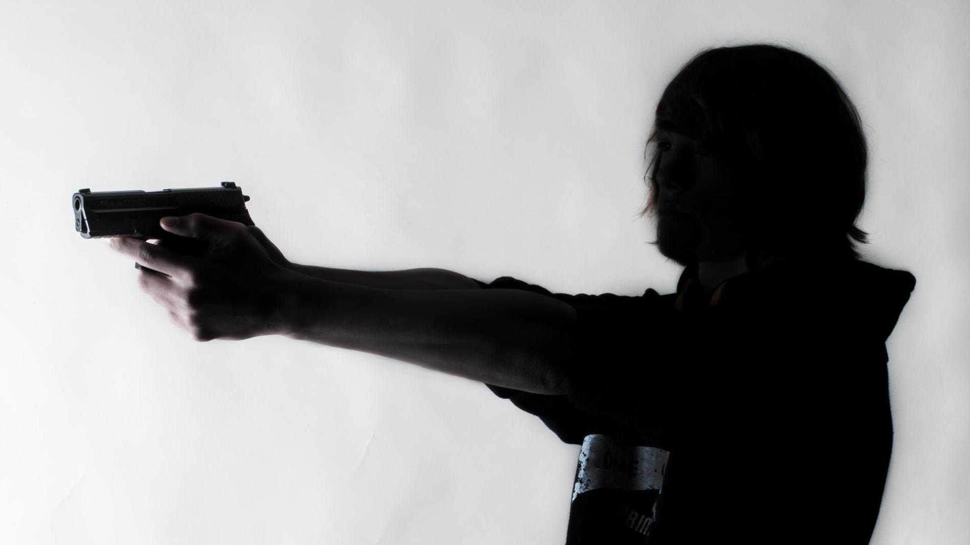 Joven apuntando con un arma