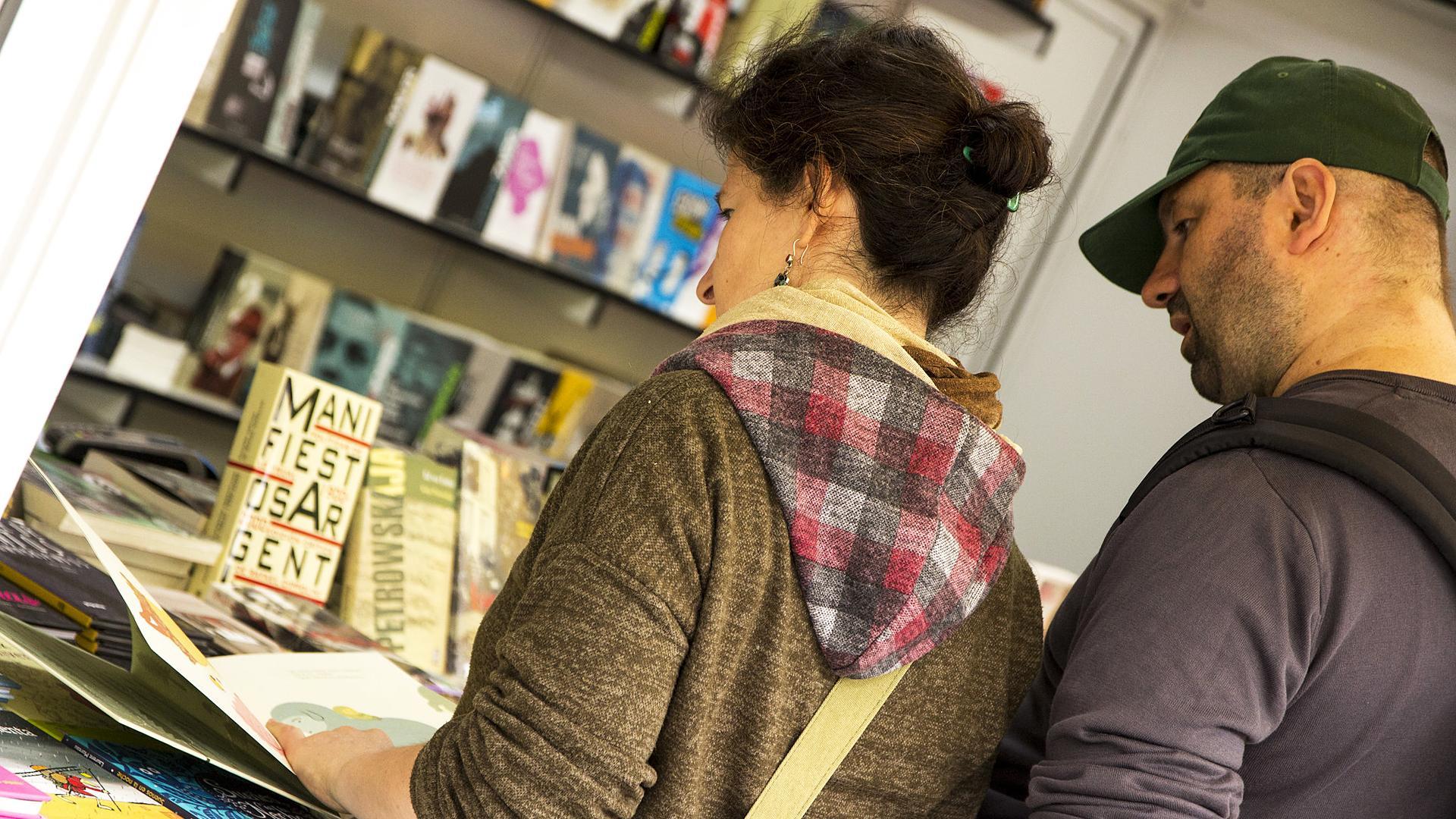 Una pareja consultando libros en una caseta de la feria del libro de Madrid 2018