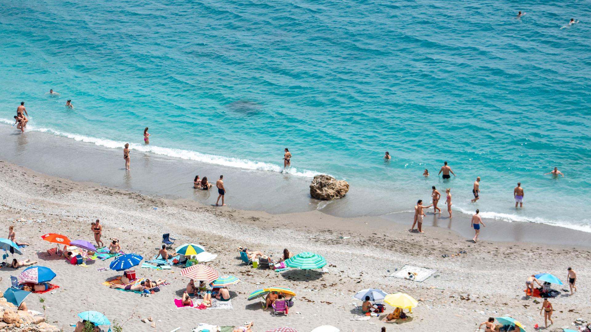 Varias personas disfrutan de la playa de la Rijana (Castell de Ferro)